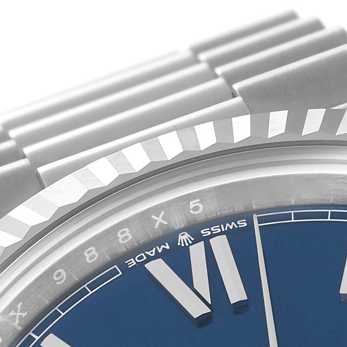 This close-up of a Rolex President 228236 Men's Platinum Blue Dial 228236 Men's Platinum Blue Dial model watch shows part of the blue dial, the Swiss Made mark, and a portion of the bracelet.