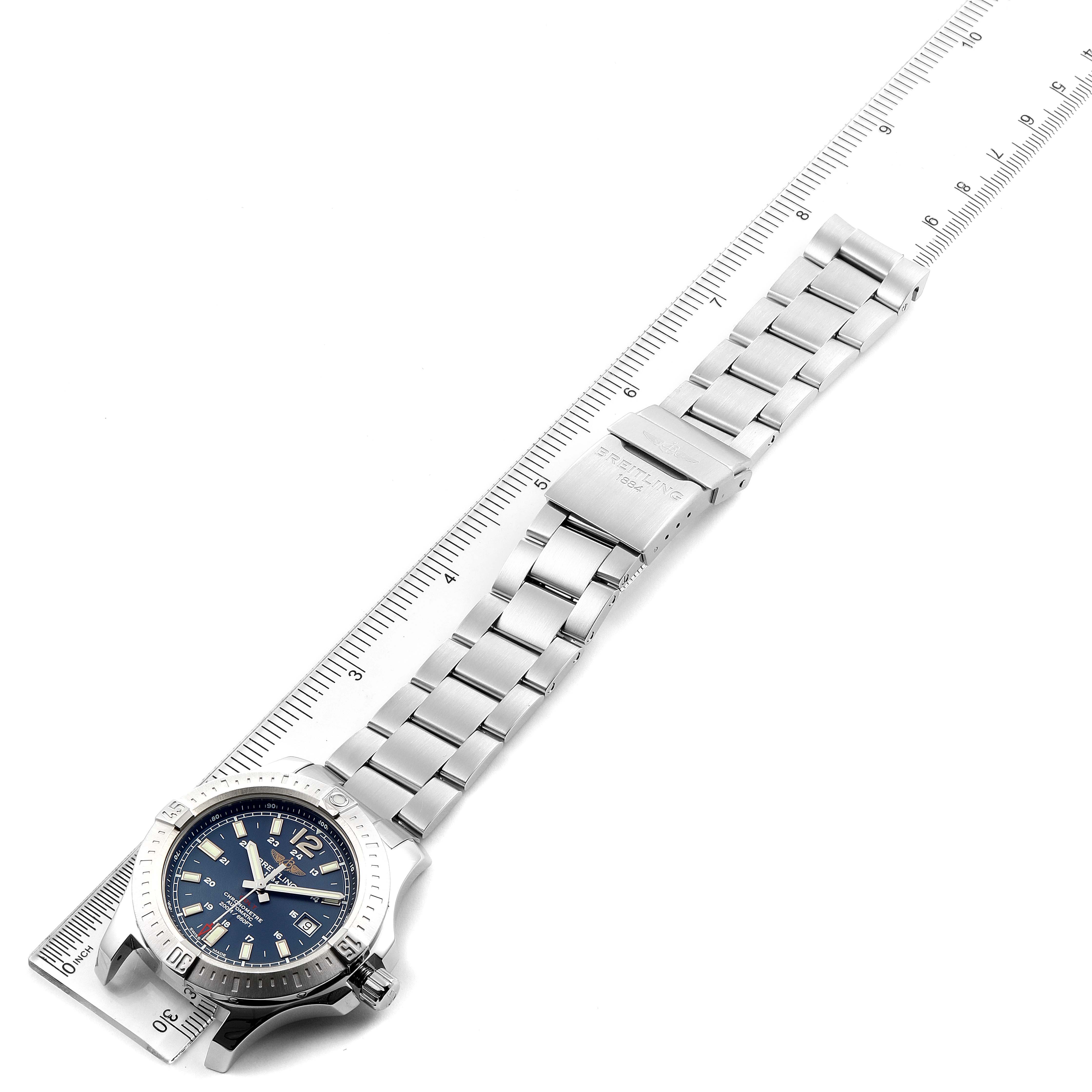 The Breitling Colt A17388 Men's Stainless Steel Blue Dial A17388 Men's Stainless Steel Blue Dial watch is shown from a top-down angle including the face and metal bracelet laid along a ruler.