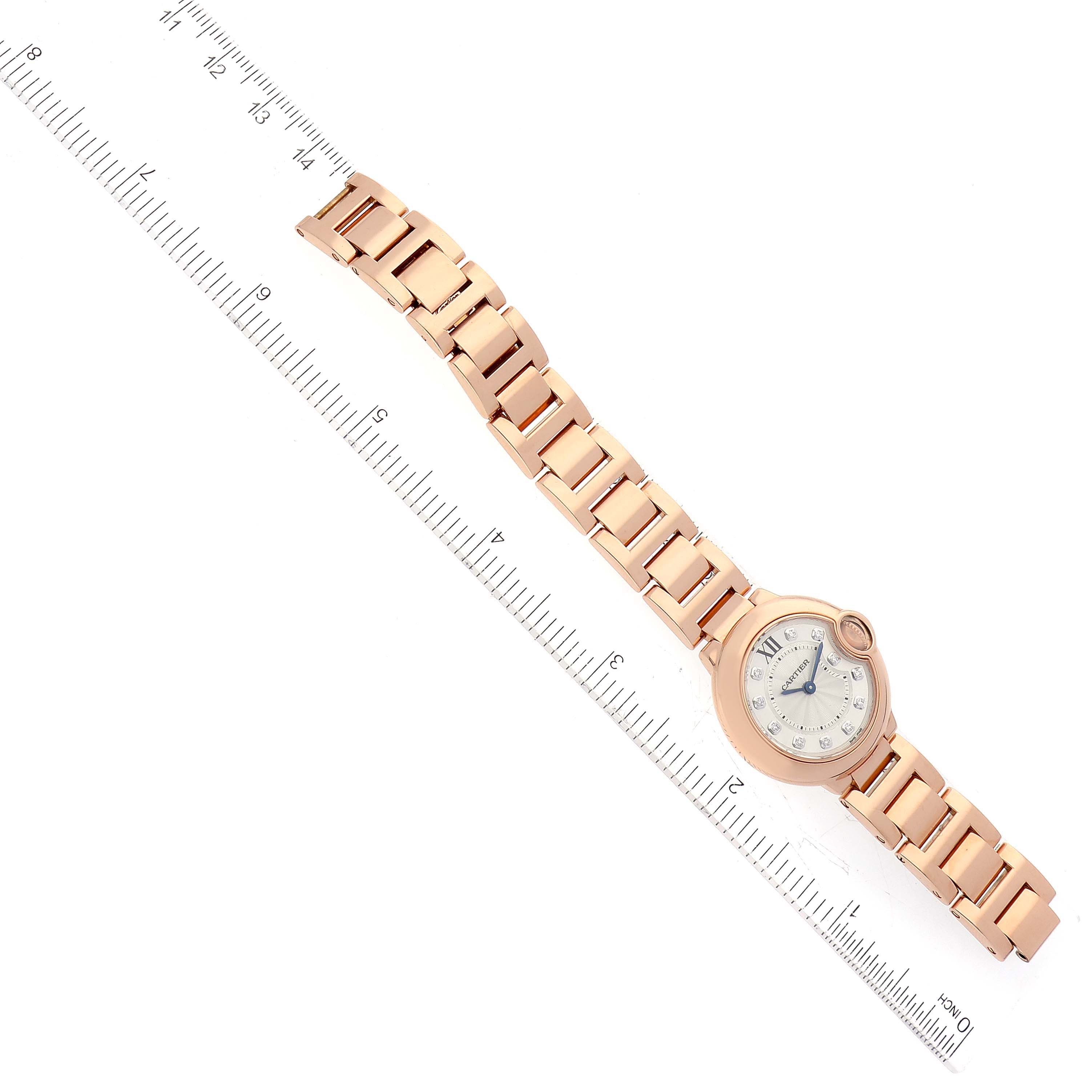 The image shows a rose gold Cartier Ballon Bleu WE902025 Women's Rose Gold Silver Dial WE902025 Women's Rose Gold Silver Dial watch with its bracelet and a ruler beside it, viewed from above.