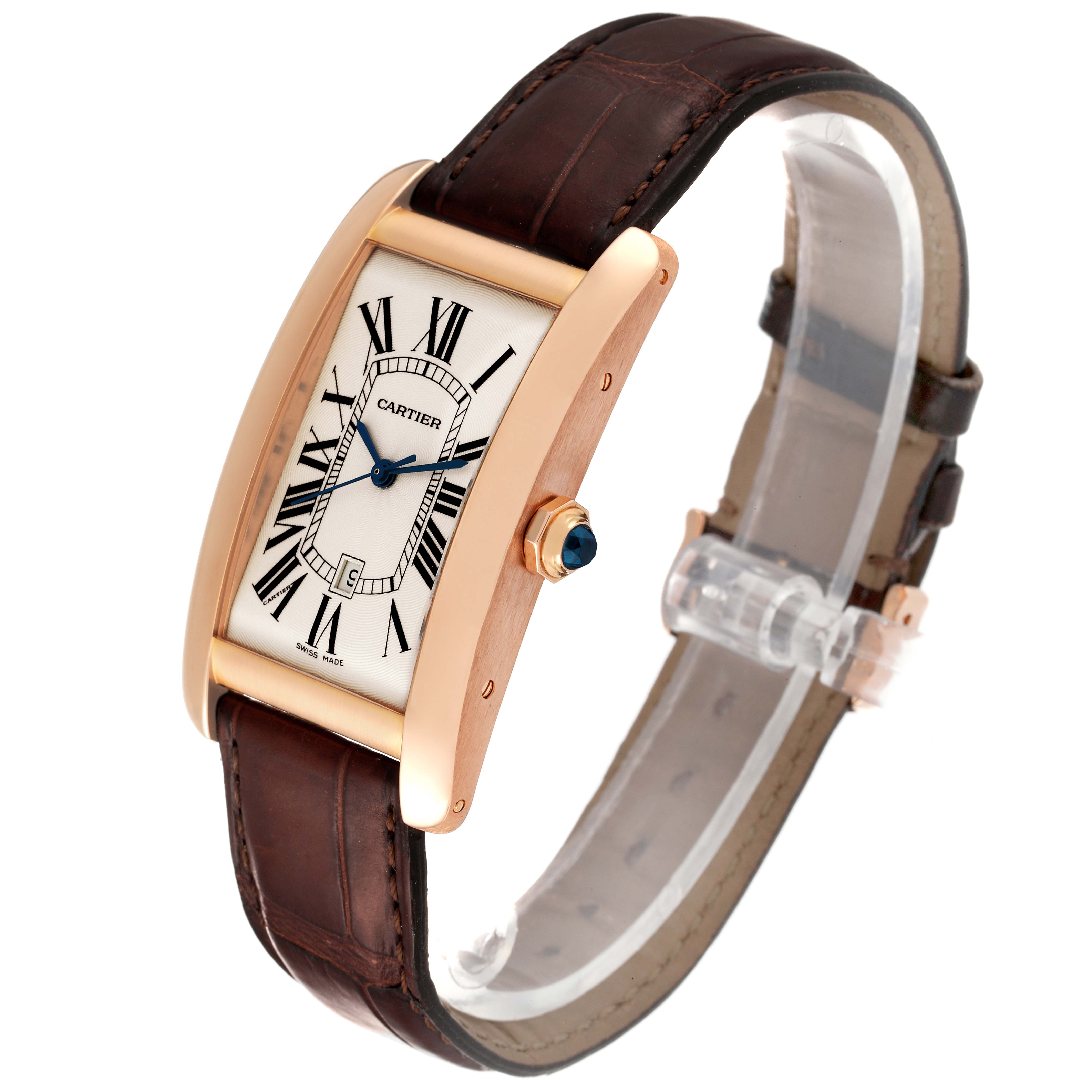 The Tank Americaine by Cartier is shown at a slight angle, highlighting its rectangular face, brown leather strap, and crown with a blue gemstone.