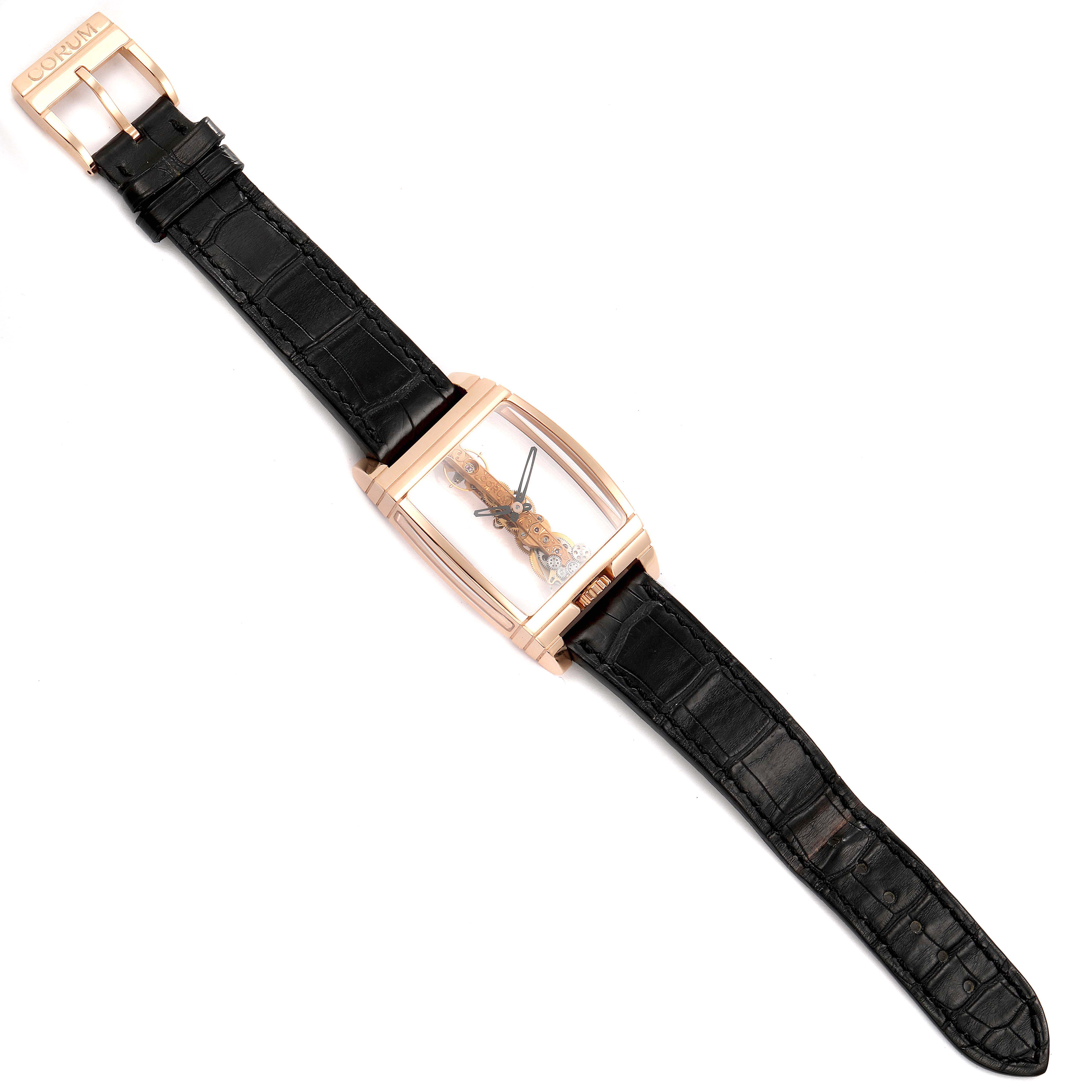 The Corum Golden Bridge B113/01043 - 113.160.55/0002 0000 Men's Rose Gold Transparent Dial watch is shown from a top view, displaying its case, dial, and black leather strap.