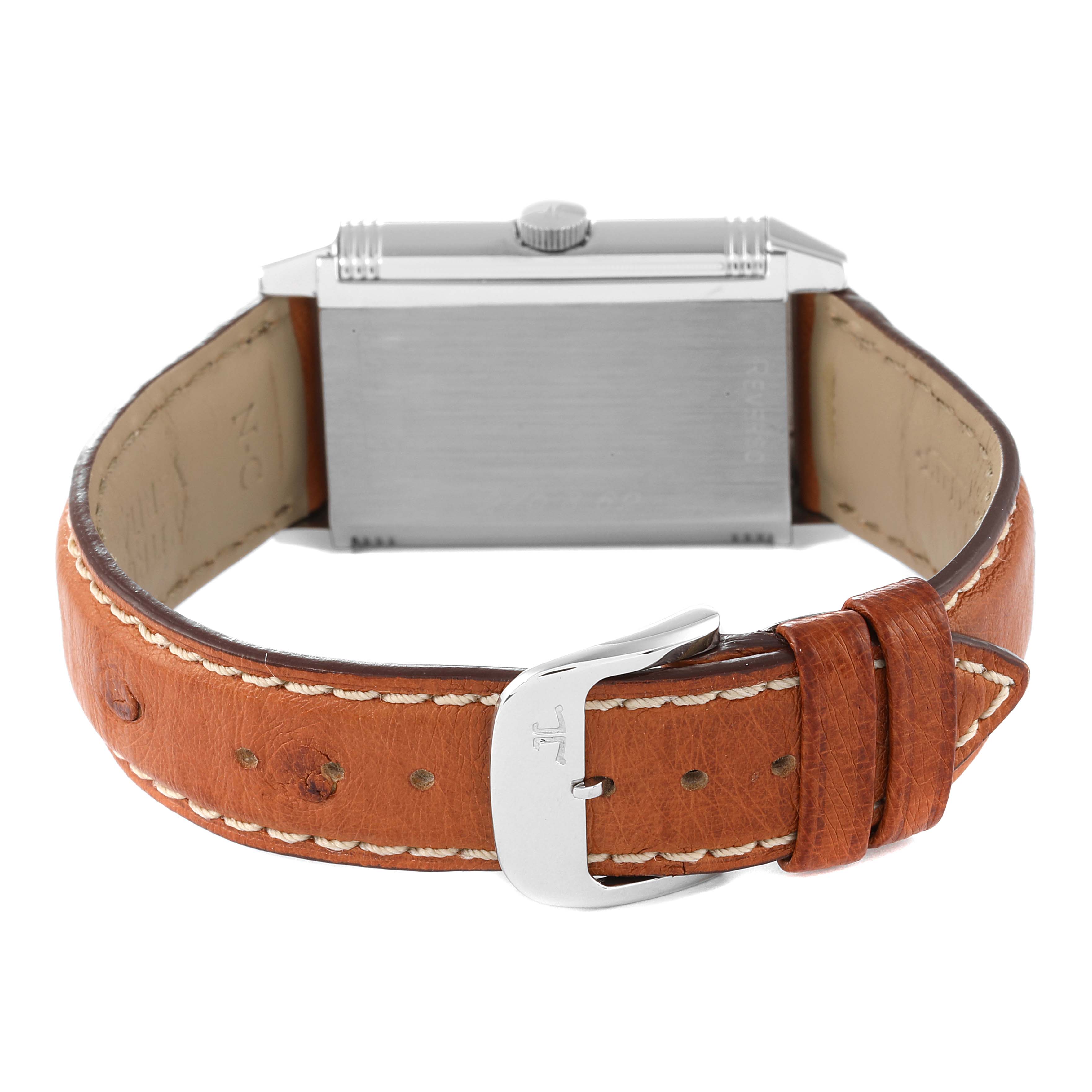The image displays the back of a Jaeger-LeCoultre Reverso watch with a brown leather strap and buckle in view.
