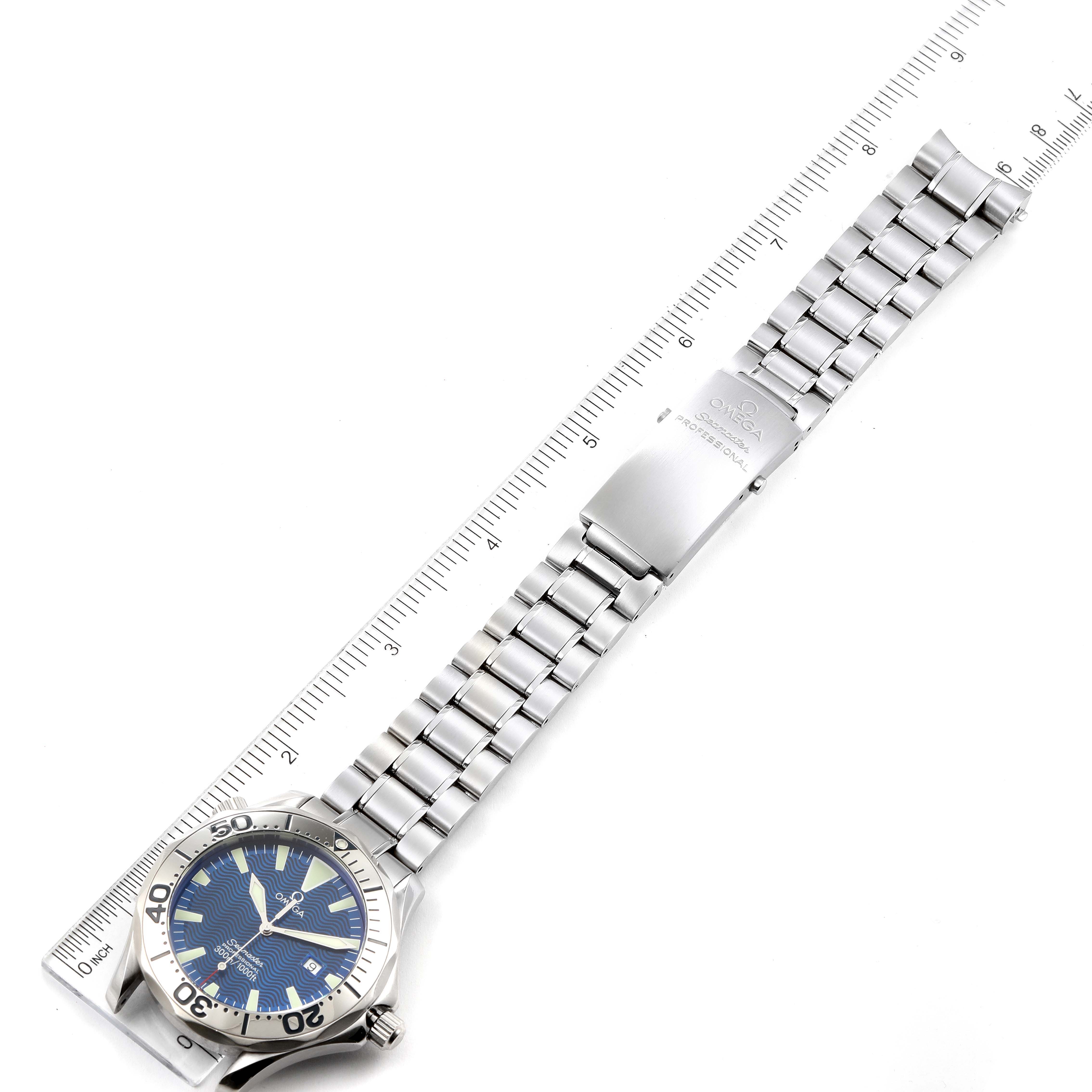 This image shows an Omega Seamaster 2265.80.00 Men's Stainless Steel Blue Dial 2265.80.00 Men's Stainless Steel Blue Dial watch laid flat, showcasing its face, bezel, bracelet, and clasp alongside a ruler.