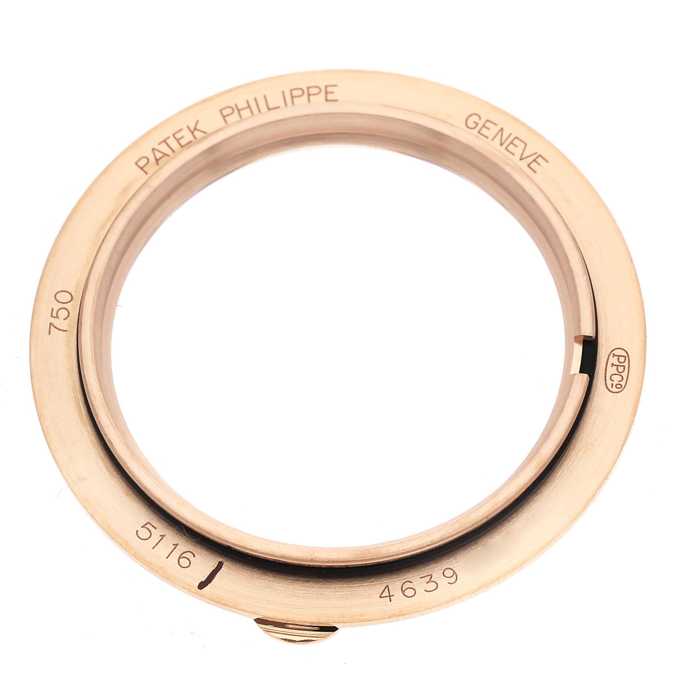 The image shows a top-down view of a Patek Philippe Calatrava 5116R Men's Rose Gold White Dial watch bezel, featuring engravings and a polished finish.