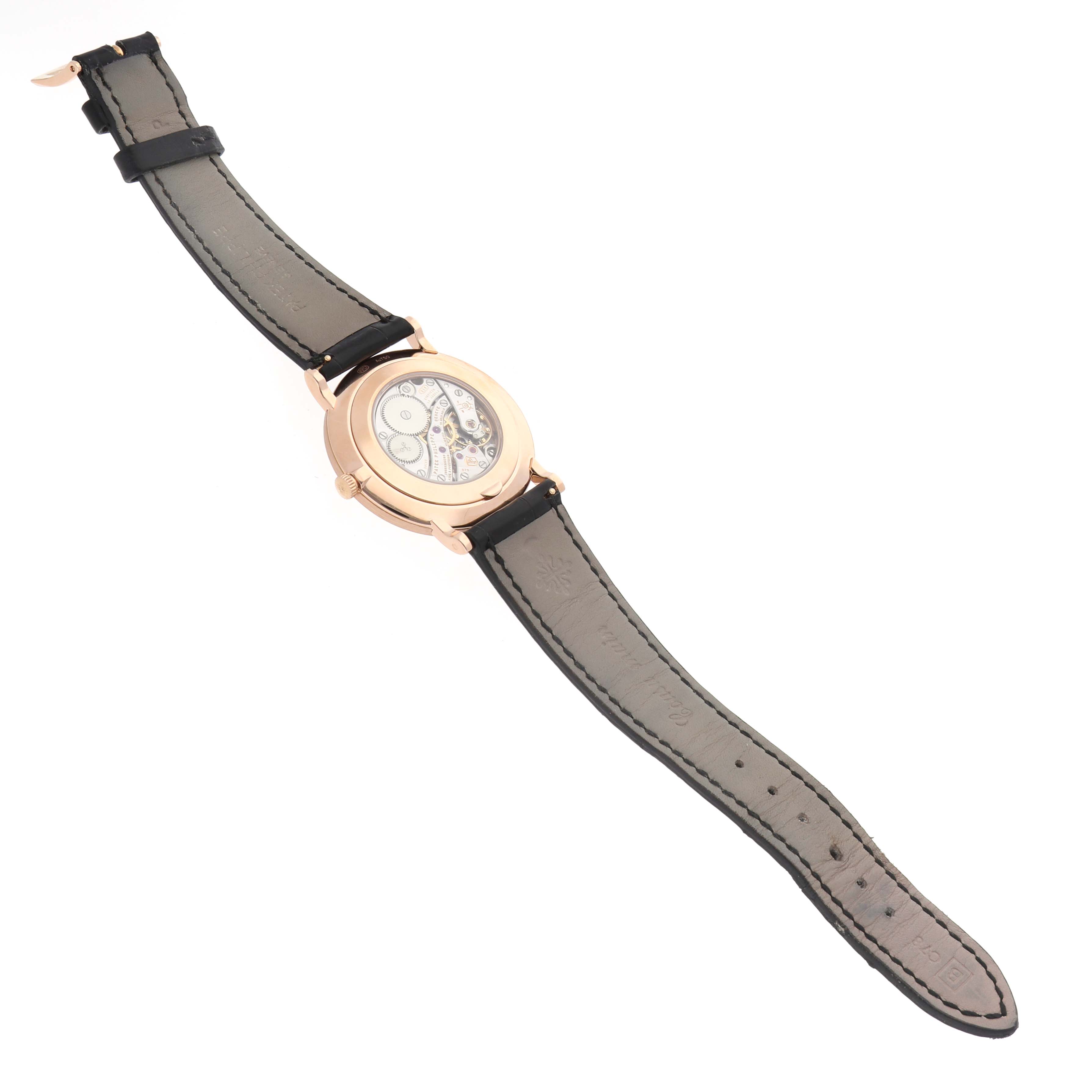 The image shows a Patek Philippe Calatrava 5116R Men's Rose Gold White Dial watch from the back, highlighting the case and movement with the leather strap extended.