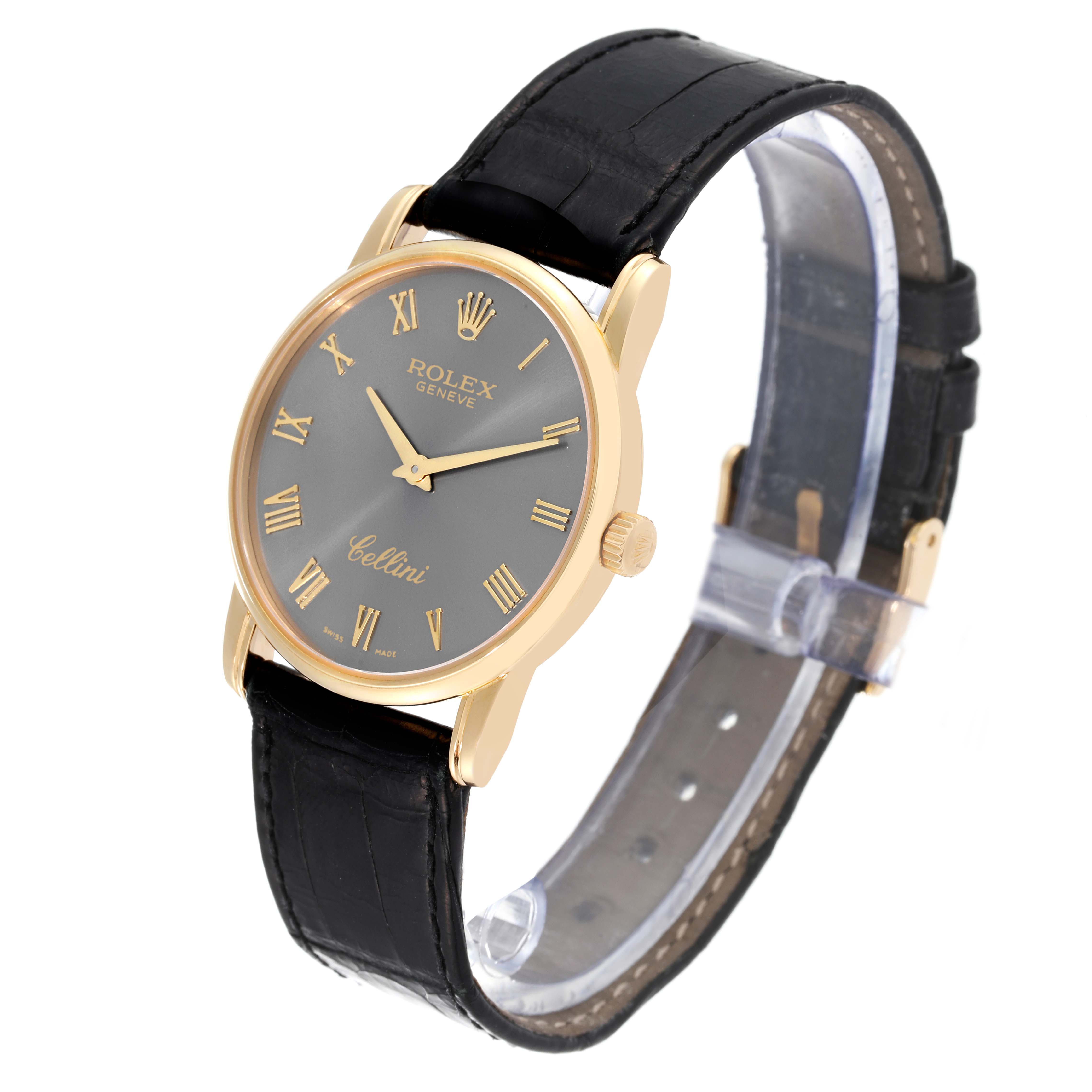 The Rolex Cellini 5116 Men's Yellow Gold Grey Dial 5116 Men's Yellow Gold Grey Dial watch is shown at a 3/4 angle, highlighting its gold case, black leather strap, and grey dial with gold Roman numerals.