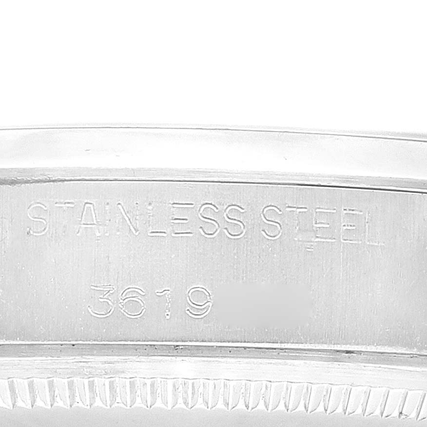 The image shows a close-up of the case side of a Rolex Date 1500 Men
s Stainless Steel Silver Dial 1500 Men
s Stainless Steel Silver Dial model, highlighting the "STAINLESS STEEL" engraving with part of the serial number.