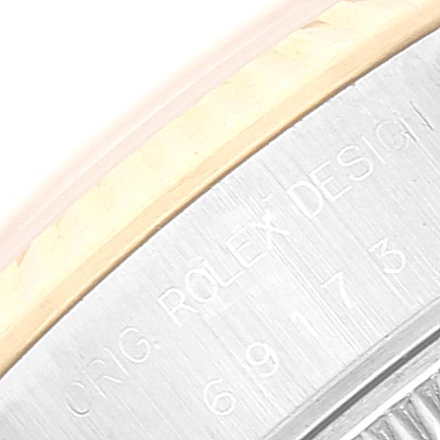 The image shows a close-up of the outer edge of the case back, featuring the "ORIG. ROLEX DESIGN" inscription of a Rolex Datejust 69173 Women's Steel and Gold (two tone) Silver Dial 69173 Women's Steel and Gold (two tone) Silver Dial watch.