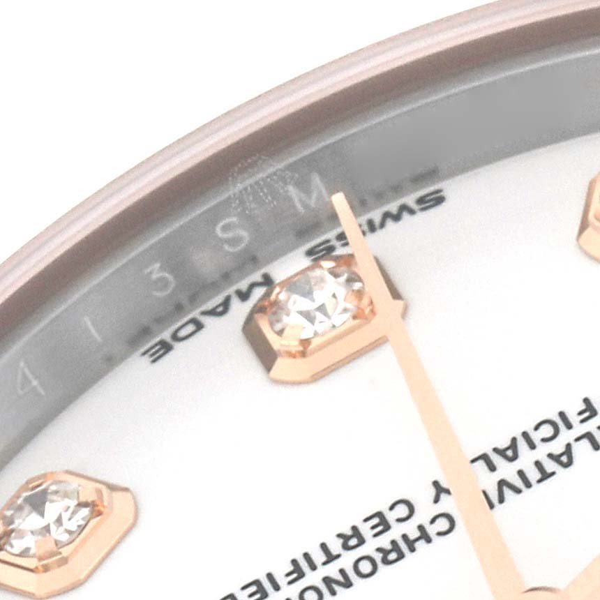 This close-up image of a Rolex Mid-Size 178271 Women's Steel and Gold (two tone) White Dial 178271 Women's Steel and Gold (two tone) White Dial model watch shows part of the dial, including diamond markers and a hand.