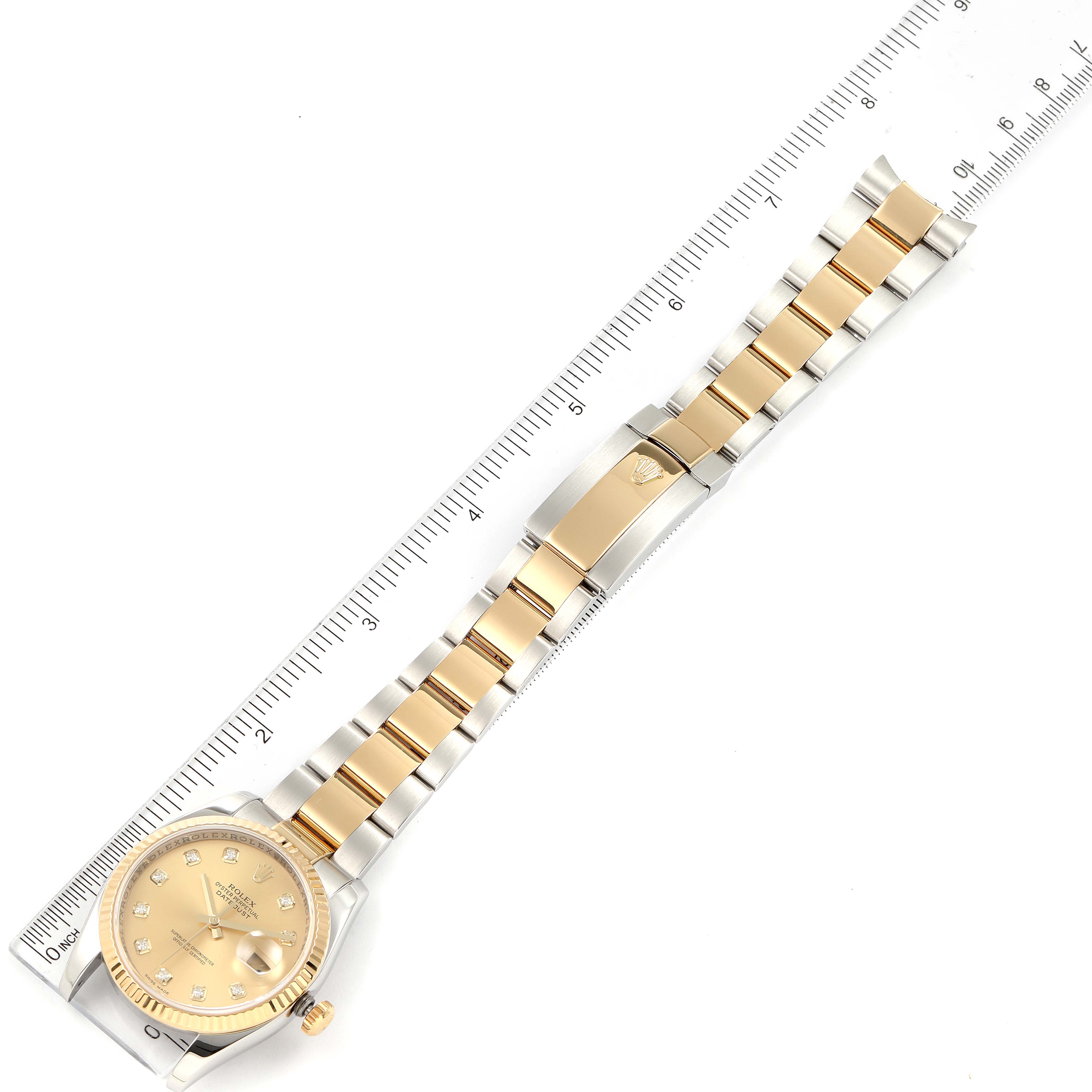 The image shows a Rolex Datejust 116233 Men's Steel and Gold (two tone) Champagne Dial 116233 Men's Steel and Gold (two tone) Champagne Dial watch laid flat with its bracelet fully extended alongside a ruler.