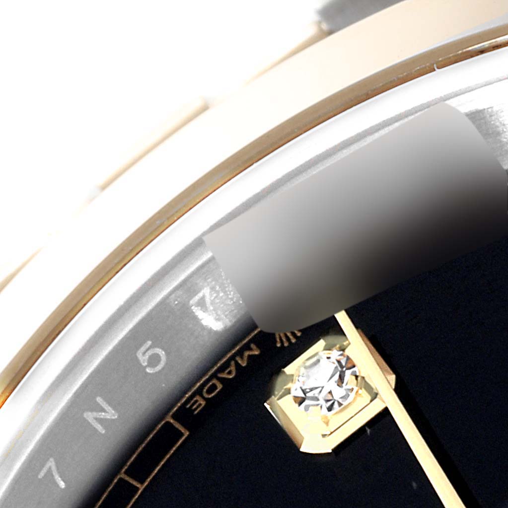 This close-up of the Rolex Datejust 41 126303 Men's Steel and Gold (two tone) Black Dial 126303 Men's Steel and Gold (two tone) Black Dial shows the dial edge, part of the bezel, and a diamond marker.