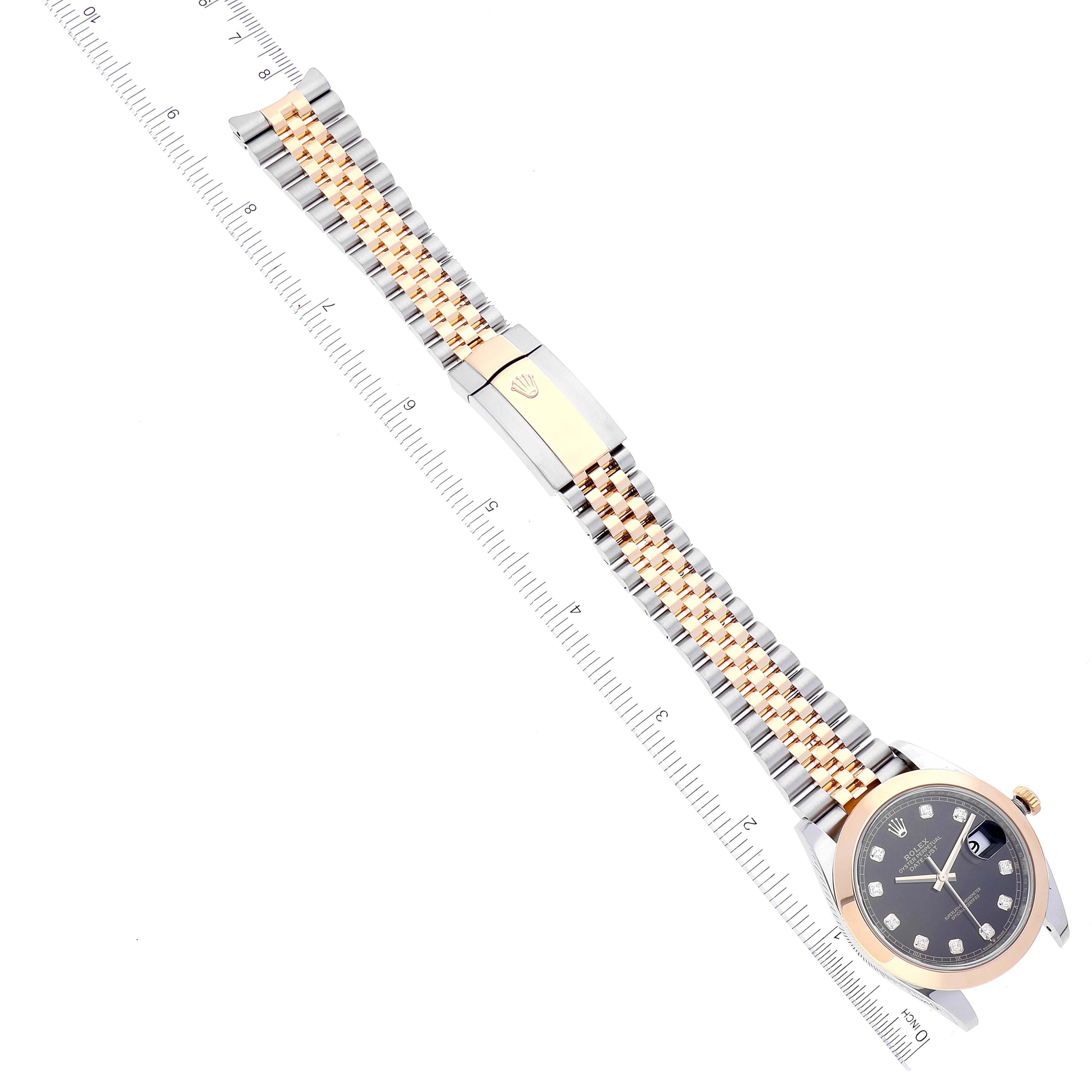 The image shows a top-down view of a Rolex Datejust 41 126303 Men's Steel and Gold (two tone) Black Dial 126303 Men's Steel and Gold (two tone) Black Dial watch with a ruler for scale, highlighting the watch face and bracelet.