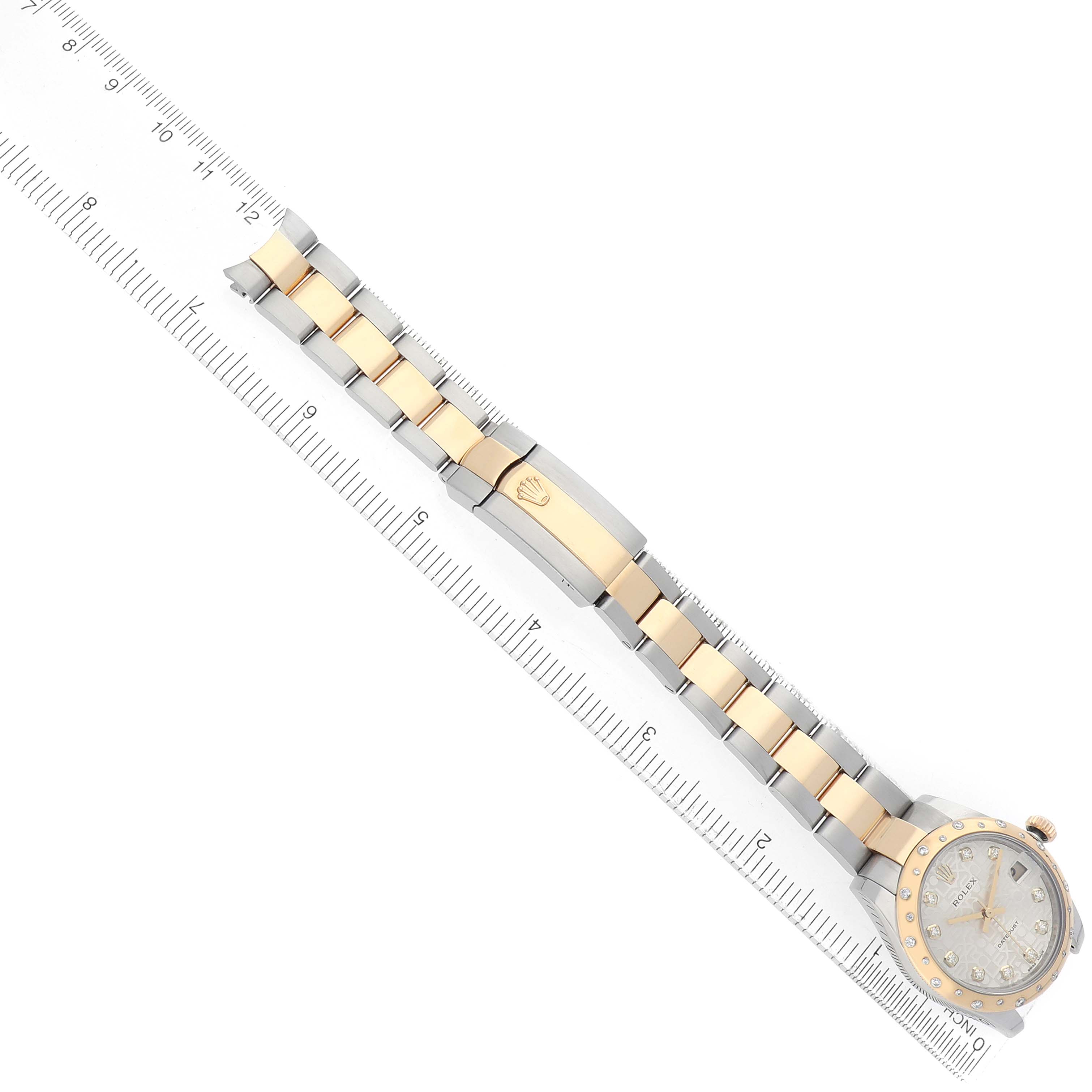The Rolex Mid-Size 178343 Women's Steel and Gold (two tone) Silver Dial watch is shown from the top, highlighting its two-tone bracelet and face, measured alongside a ruler.