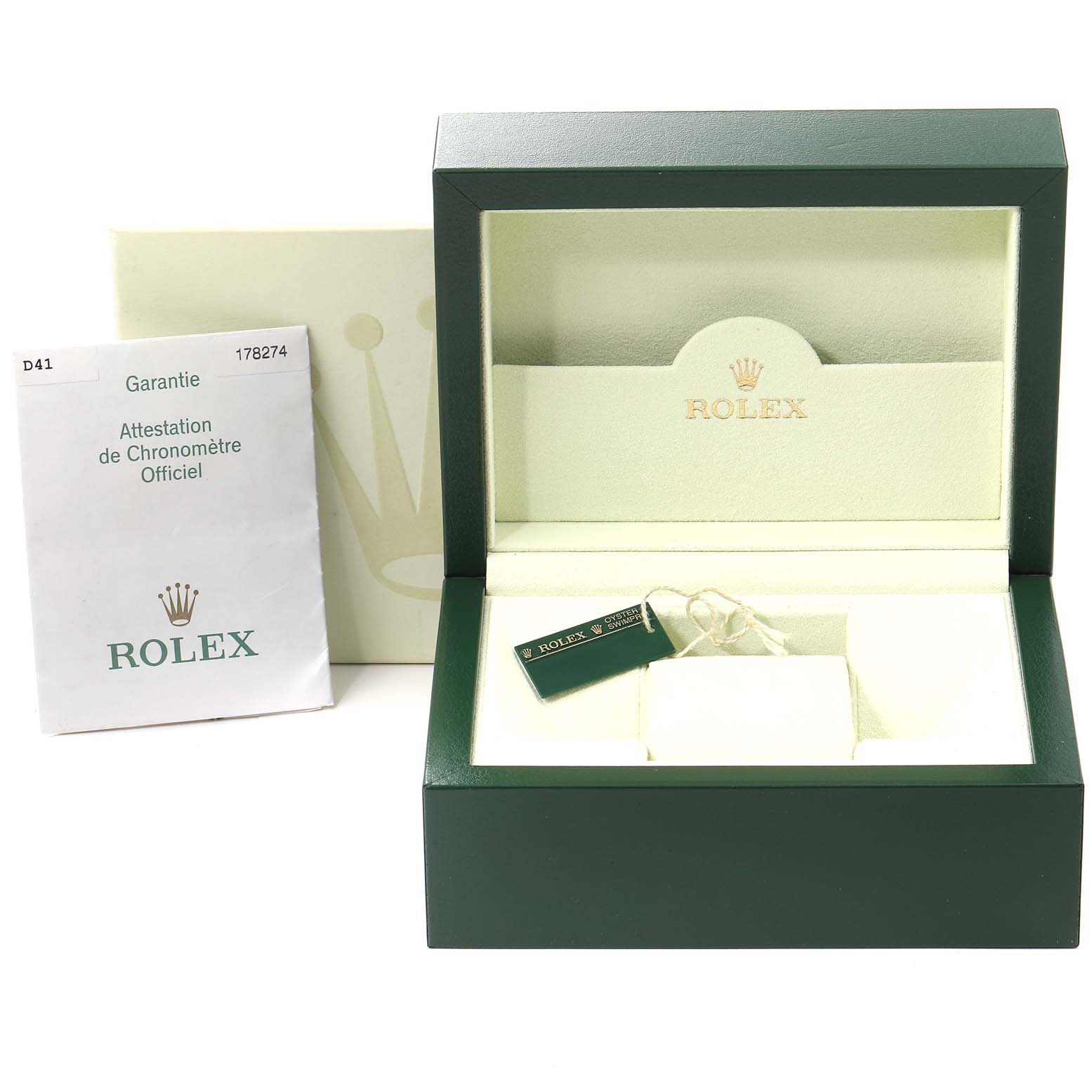 The image shows the open green box, an outer box, a tag, and warranty papers for a Mid-Size Rolex watch.
