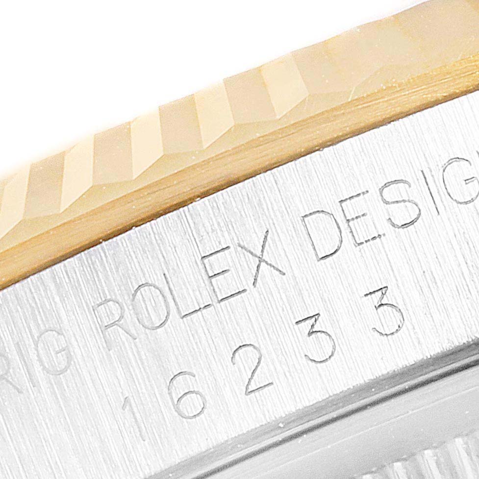 This image shows a close-up of the bezel and engraved case side of a Rolex Datejust 16233 Men's Steel and Gold (two tone) Champagne Dial 16233 Men's Steel and Gold (two tone) Champagne Dial watch.