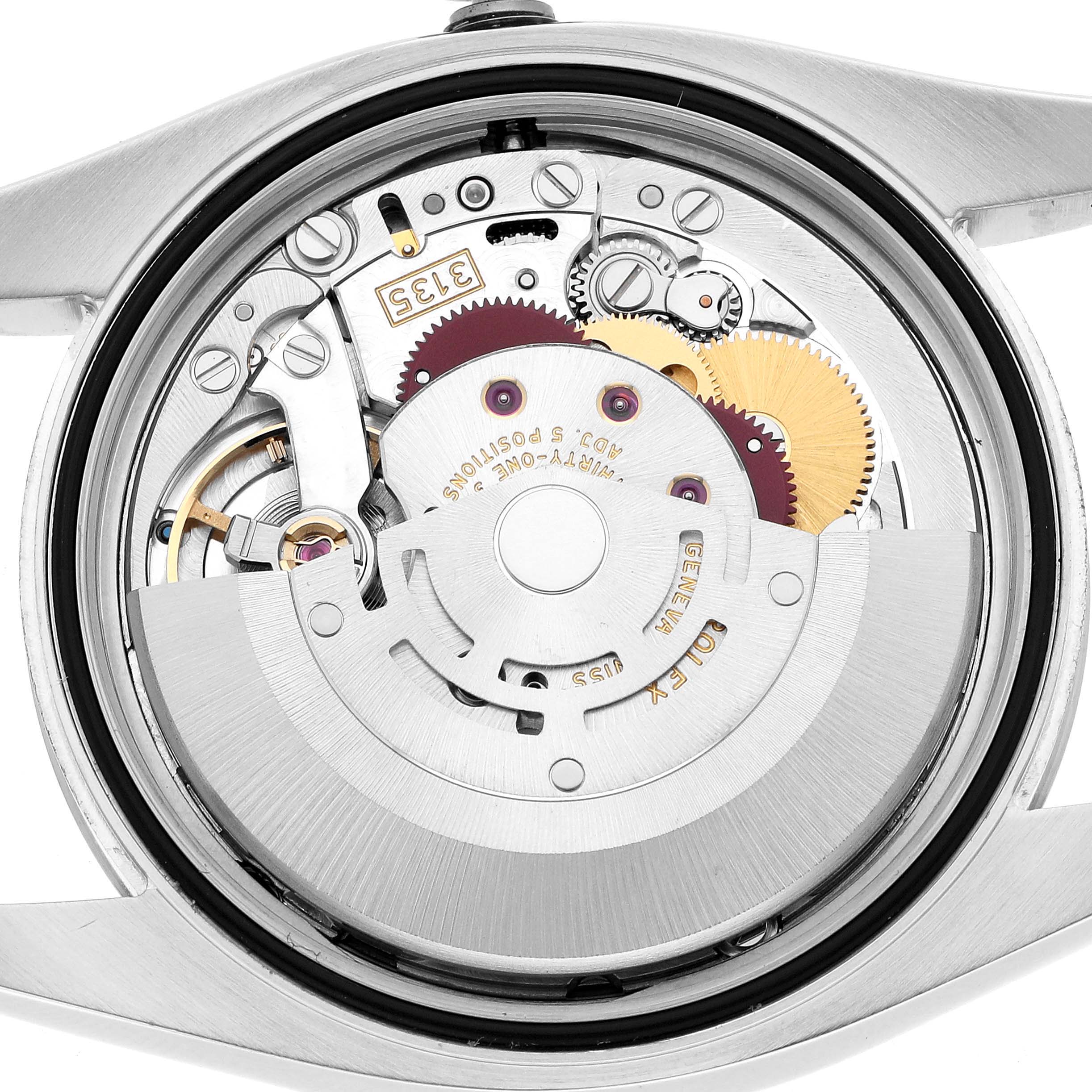The image shows the internal movement of a Rolex Datejust 116200 Men
s Stainless Steel White Dial watch, featuring gears and mechanical components from a back angle.