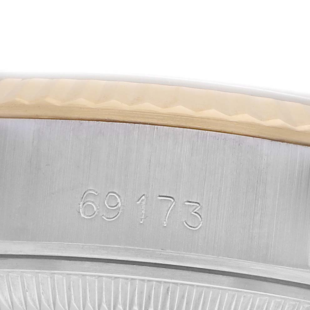 The image shows a close-up of the side of a Rolex Datejust 69173 Women's Steel and Gold (two tone) Black Dial watch, focusing on the engraved reference number.
