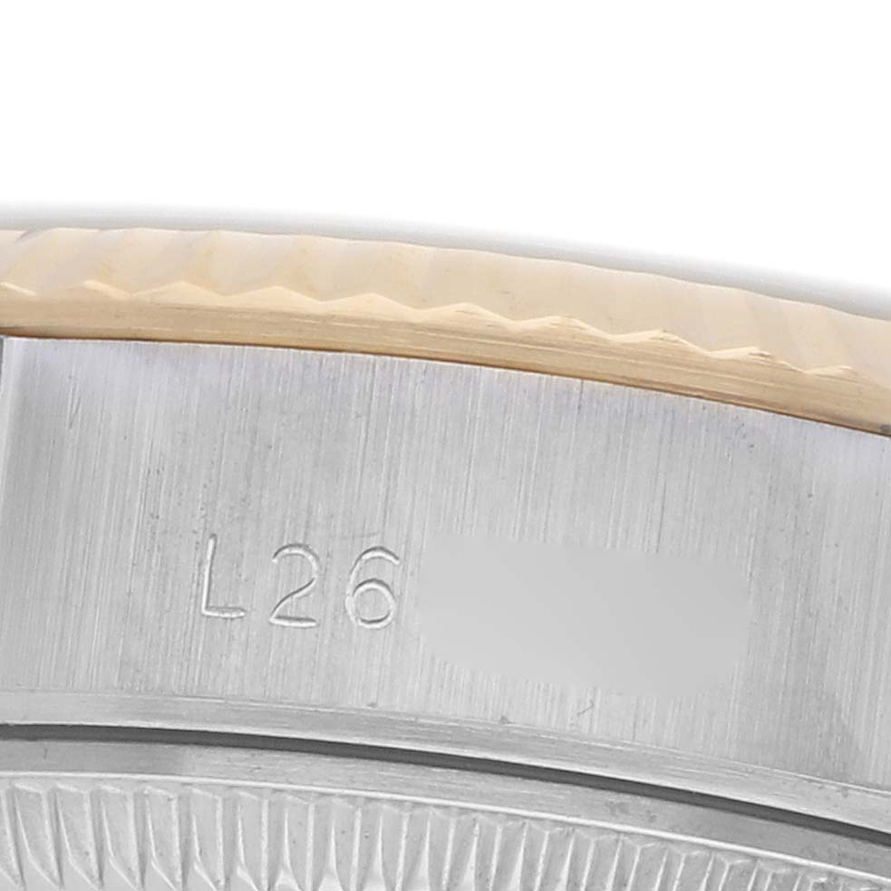 The image shows a close-up of the case edge and bezel of a Rolex Datejust 69173 Women's Steel and Gold (two tone) Black Dial, featuring a partial serial engraving.