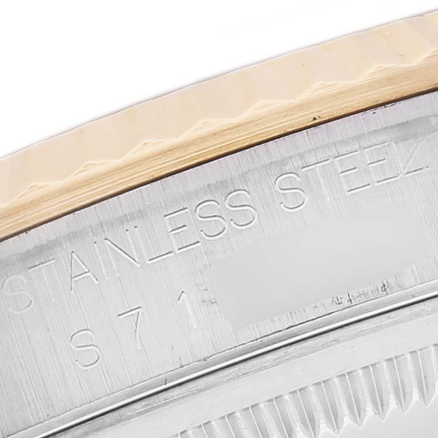 This close-up image shows a part of the stainless steel and gold fluted bezel of a Rolex Datejust 16233 Men's Steel and Gold (two tone) Blue Dial 16233 Men's Steel and Gold (two tone) Blue Dial watch.