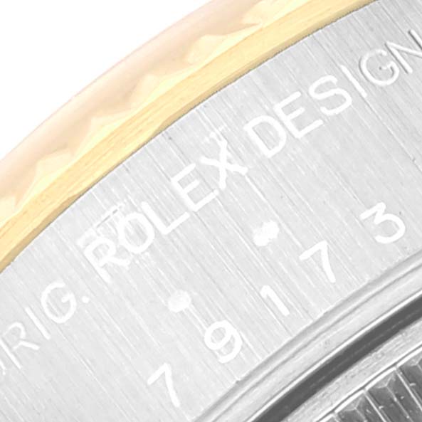The image shows a close-up of the case side of a Rolex Datejust 79173 Women's Steel and Gold (two tone) Champagne Dial 79173 Women's Steel and Gold (two tone) Champagne Dial model, displaying part of the model's engraving.