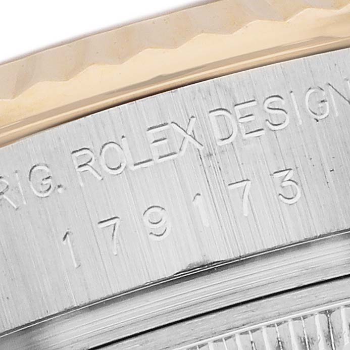 The image shows a close-up of the Rolex Datejust 179173 Women's Steel and Gold (two tone) Black Dial watch's engraved case side.