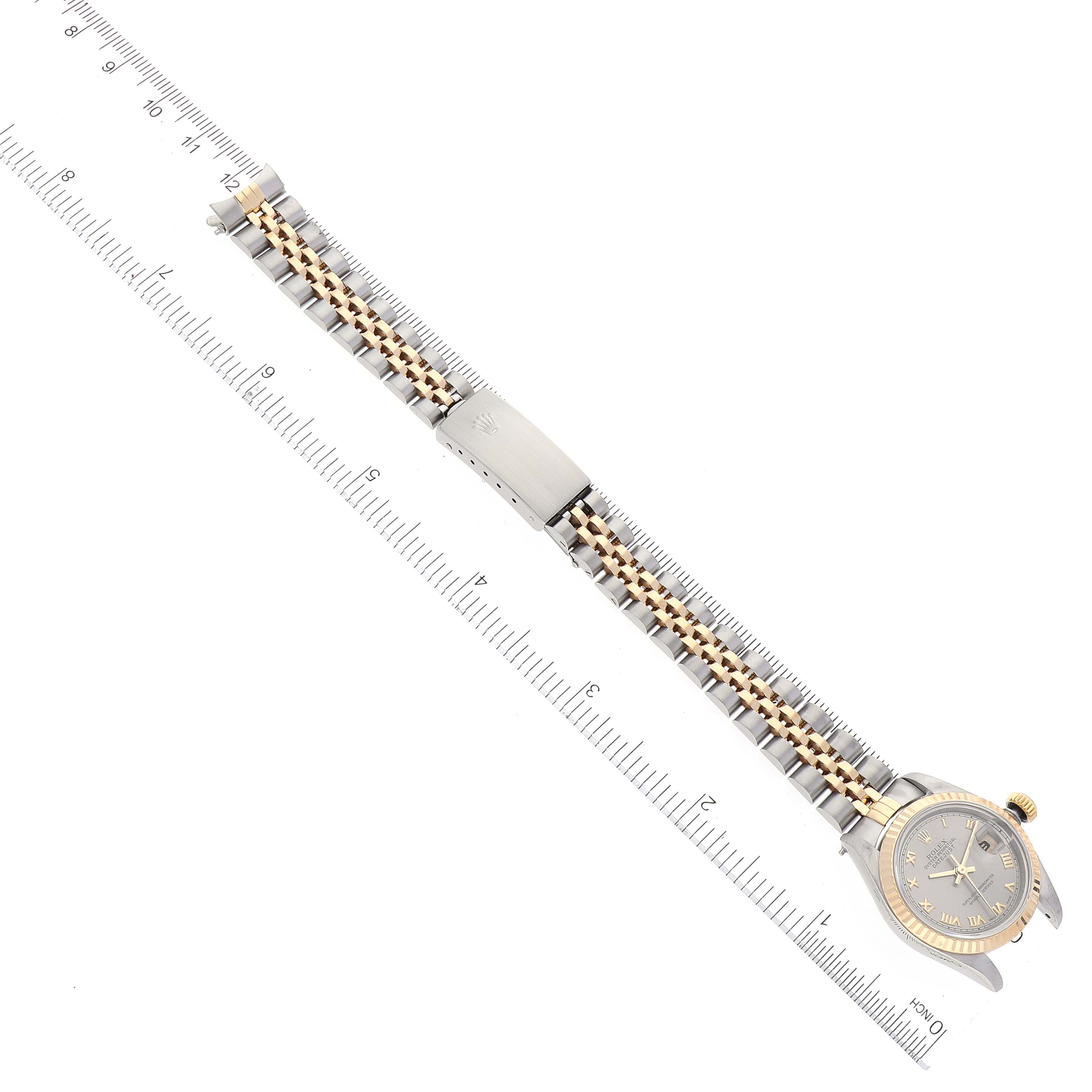 The image shows a top-down view of a Rolex Datejust 69173 Women
s Steel and Gold (two tone) Grey Dial 69173 Women
s Steel and Gold (two tone) Grey Dial watch, highlighting its dial, bezel, and two-tone bracelet against a ruler.