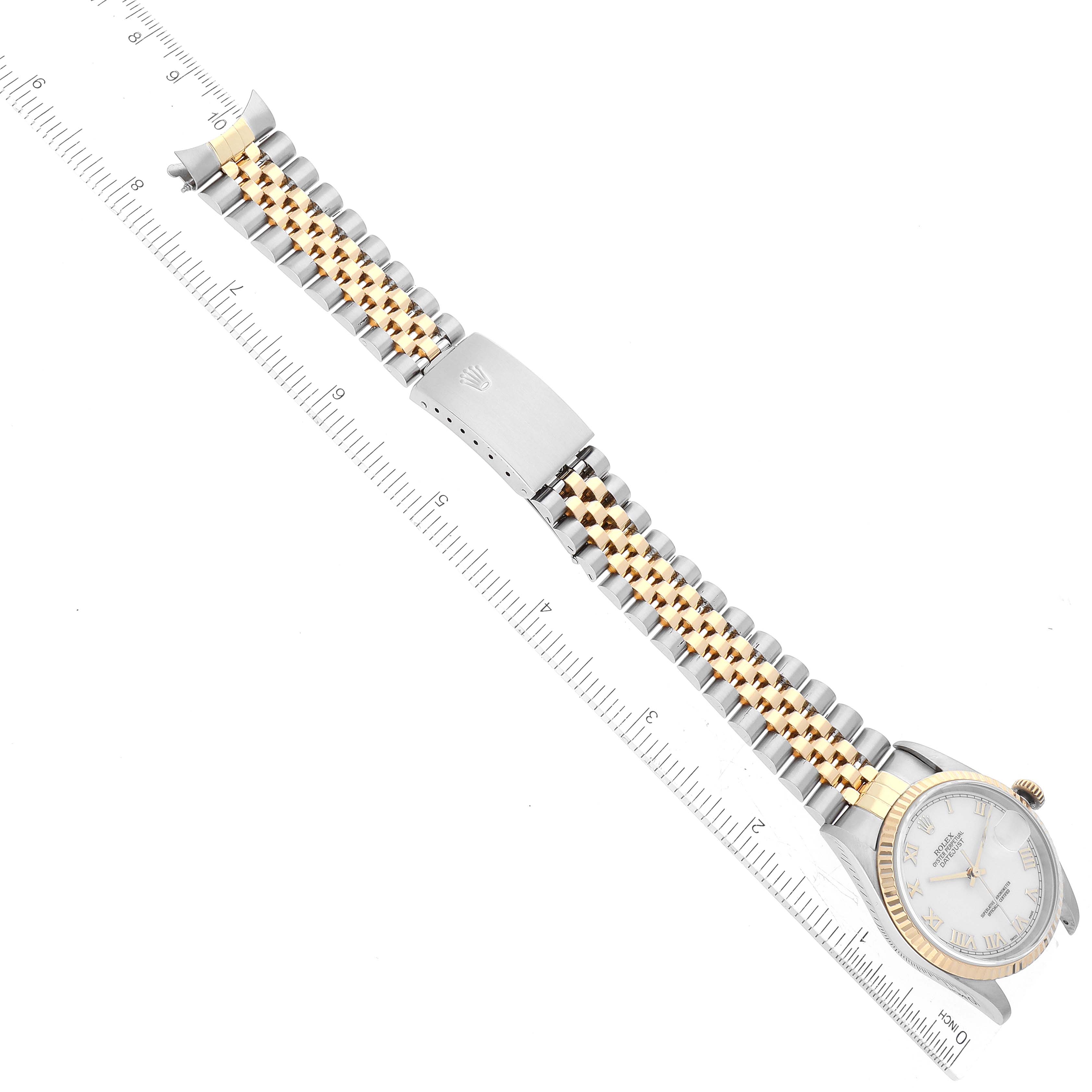 The image shows a Rolex Datejust 16233 Men's Steel and Gold (two tone) White Dial 16233 Men's Steel and Gold (two tone) White Dial watch laid flat, displaying its face, bracelet, and clasp alongside a measurement scale.