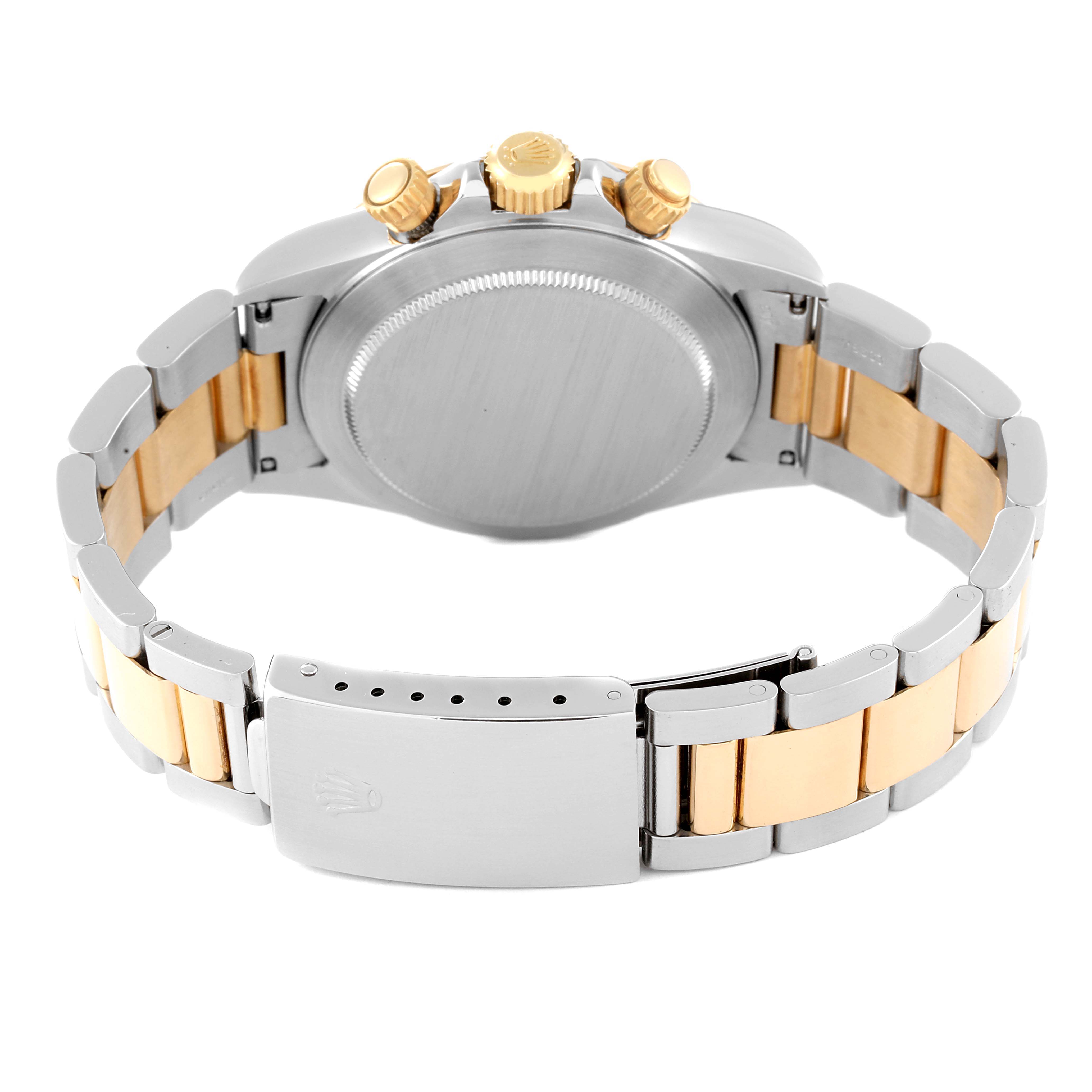 The image shows the back view of a Rolex Daytona 16523 Men's Steel and Gold (two tone) Champagne Dial 16523 Men's Steel and Gold (two tone) Champagne Dial watch, highlighting its case, crown, push buttons, and two-tone bracelet with a clasp.