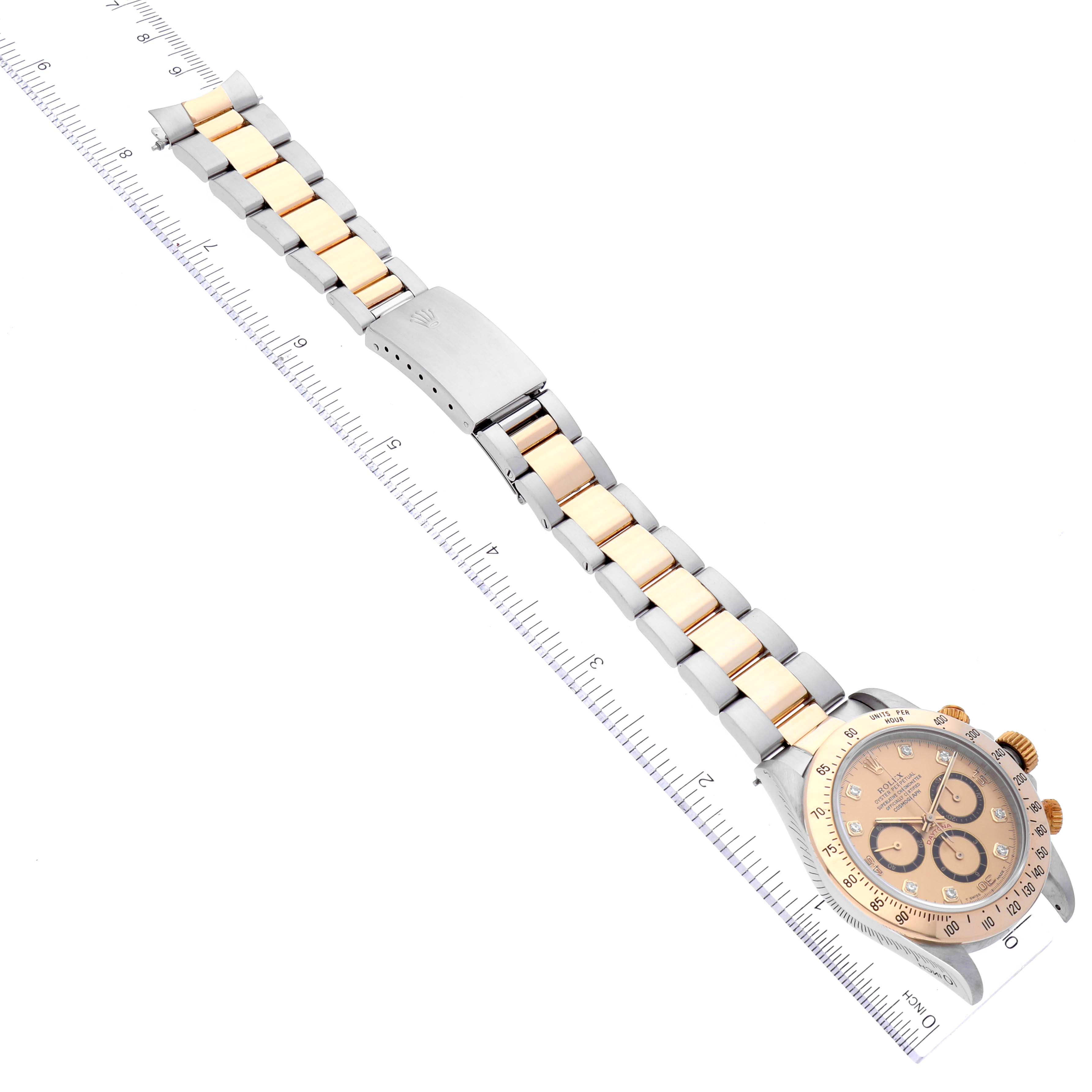 This Rolex Daytona 16523 Men's Steel and Gold (two tone) Champagne Dial 16523 Men's Steel and Gold (two tone) Champagne Dial watch is shown from above, displaying the full length of its band and face with a measurement ruler beside it.
