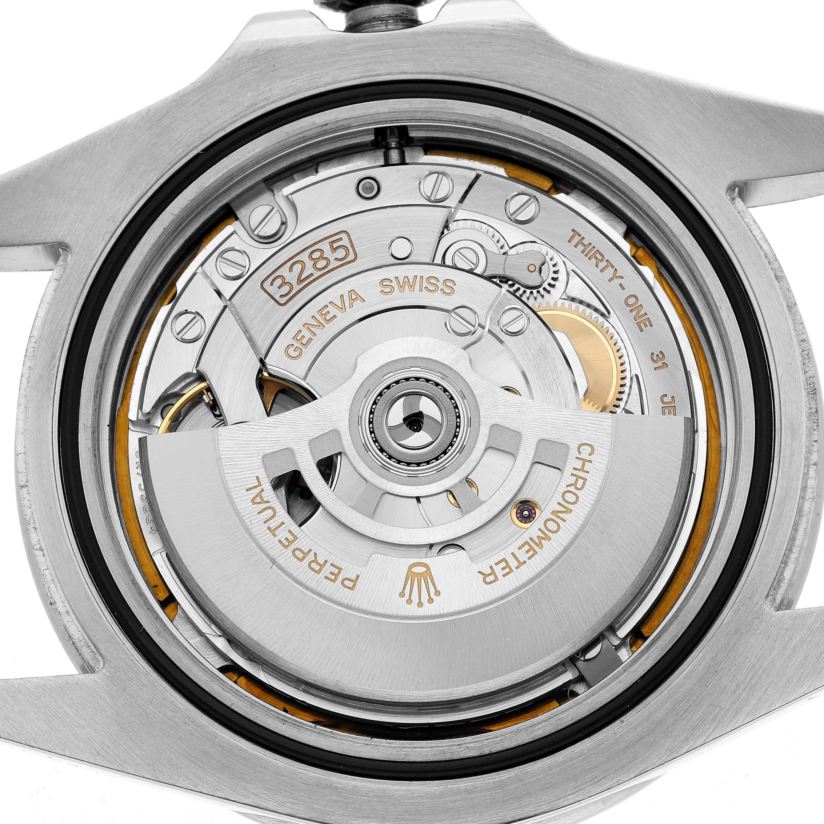 The image shows the movement mechanism of a Rolex Explorer 226570 Men
s Stainless Steel White Dial watch viewed from the back, highlighting gears and engravings.