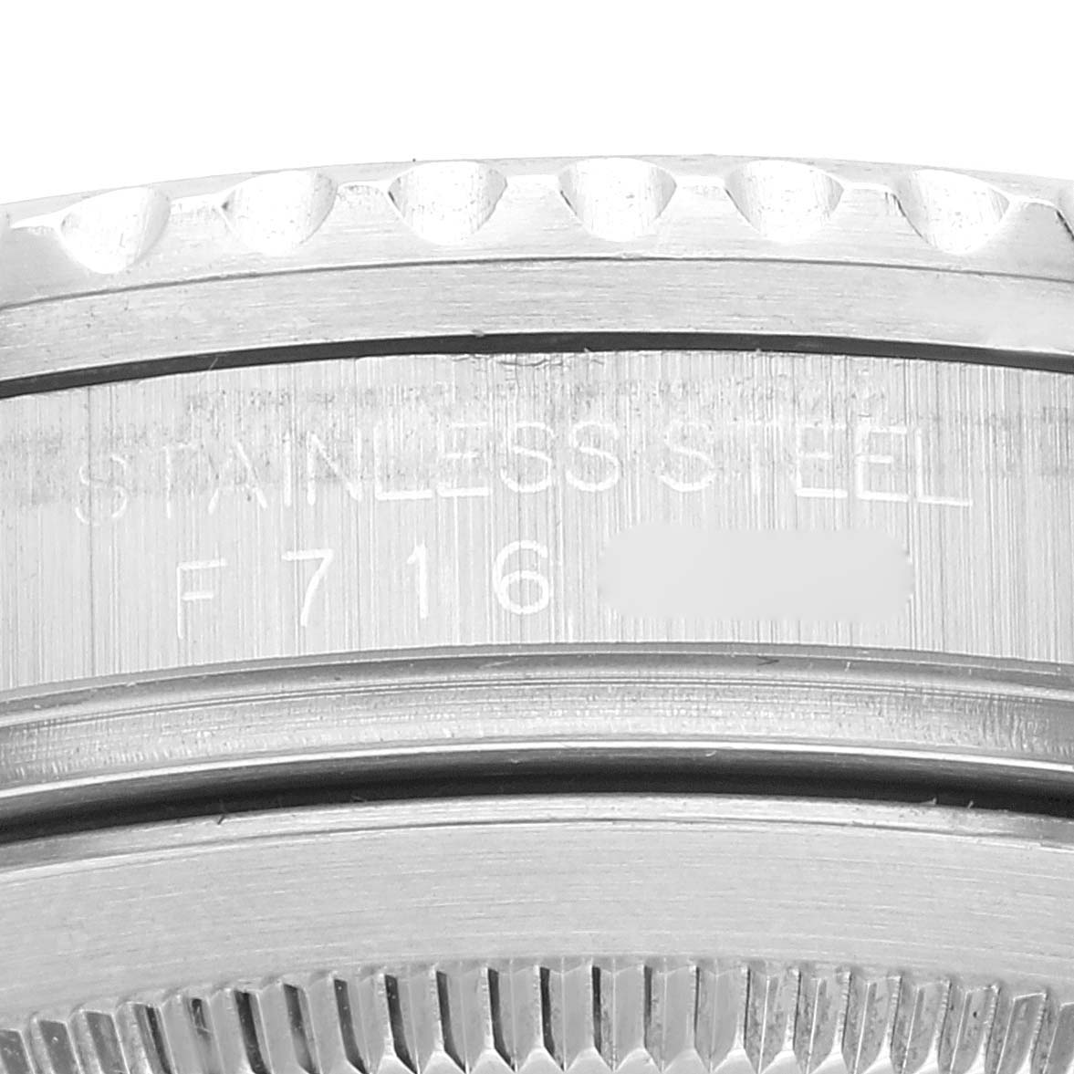 This close-up image shows the stainless steel case and engraved serial number of a Rolex GMT-Master 16710 Men's Stainless Steel Black Dial 16710 Men's Stainless Steel Black Dial watch.
