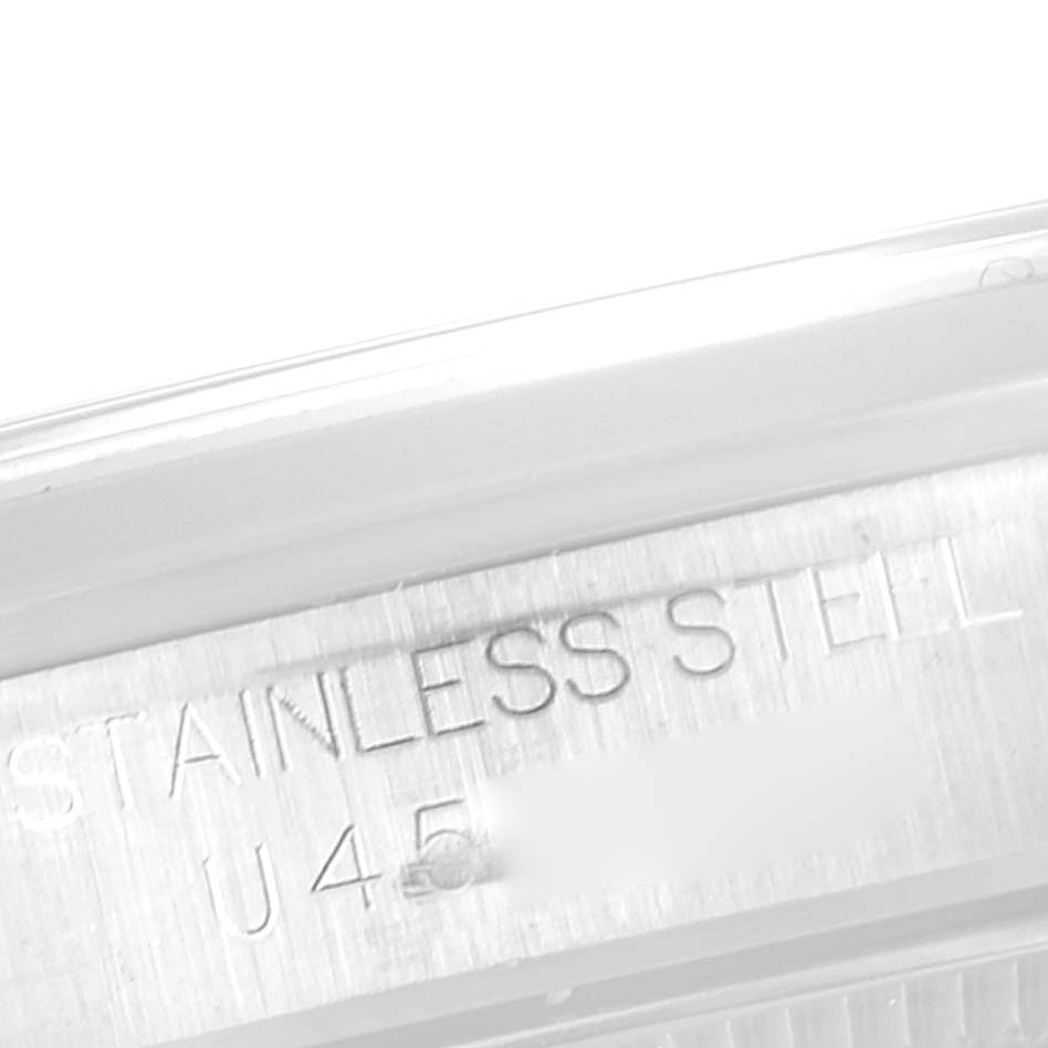 The image shows a close-up of the side case of a Rolex Mid-Size 67480 Women's Stainless Steel Black Dial 67480 Women's Stainless Steel Black Dial model, featuring the "STAINLESS STEEL" engraving.