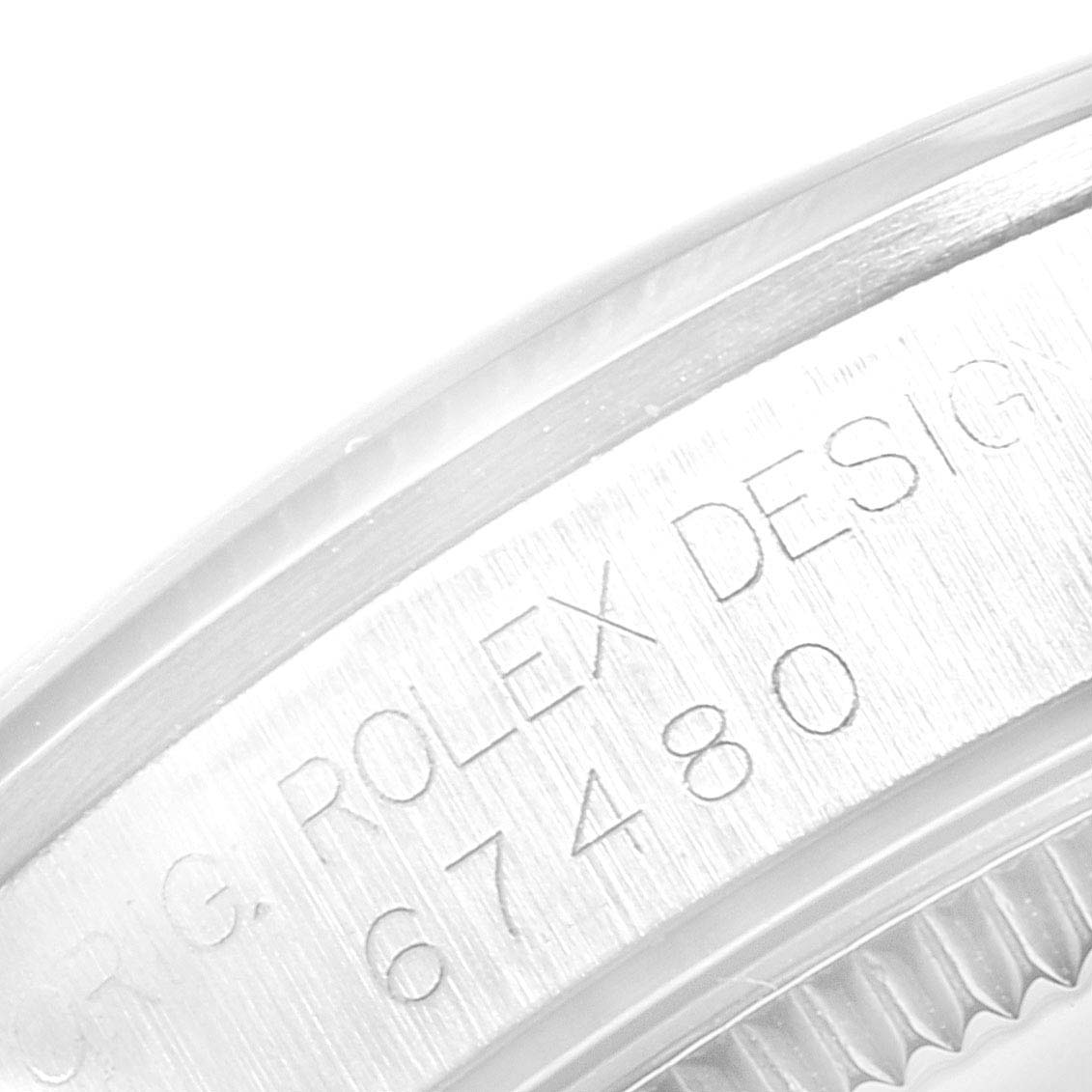 This close-up image shows the engraved design and serial number on the case back edge of a mid-size Rolex watch.