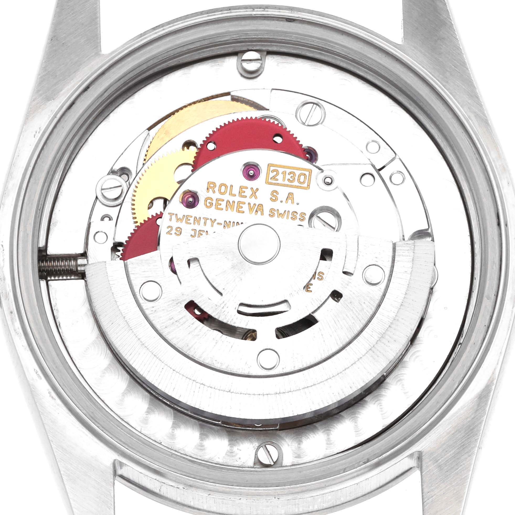 The image shows the inner movement of a Rolex Mid-Size 67480 Women's Stainless Steel Pink Dial model, viewed from the back, highlighting its intricate gears and components.