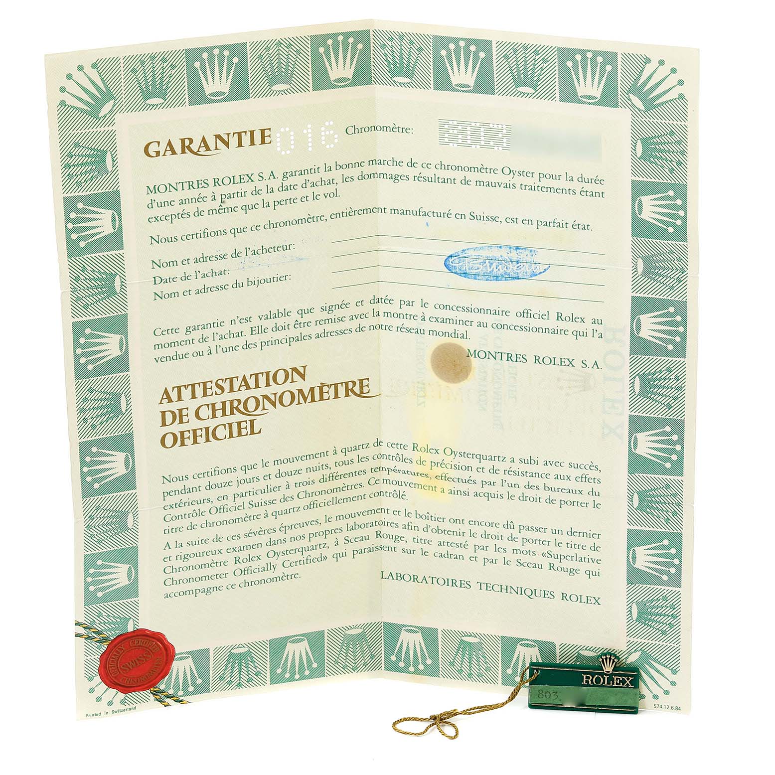 This image shows warranty paperwork and a hang tag for a Rolex Oysterquartz 19018 Men's Yellow Gold Black Dial 19018 Men's Yellow Gold Black Dial watch.