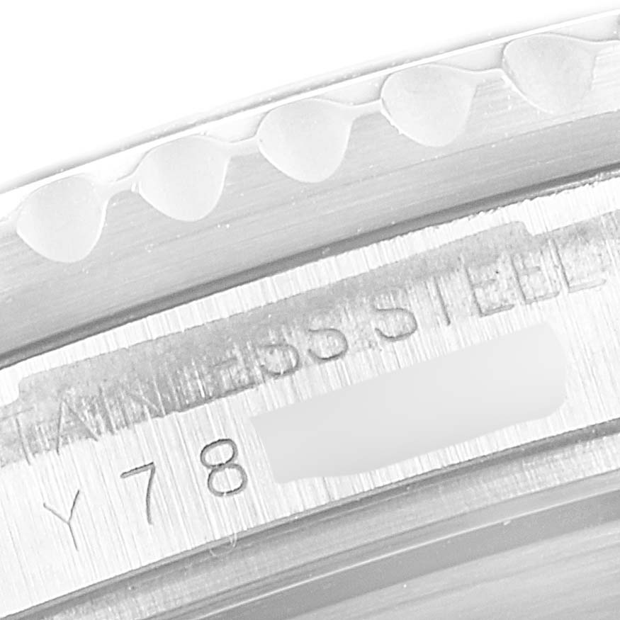 The image shows a close-up angle of the Rolex Submariner 16610 Men
s Stainless Steel Black Dial 16610 Men
s Stainless Steel Black Dial
s case, highlighting the serial number and "STAINLESS STEEL" engraving.