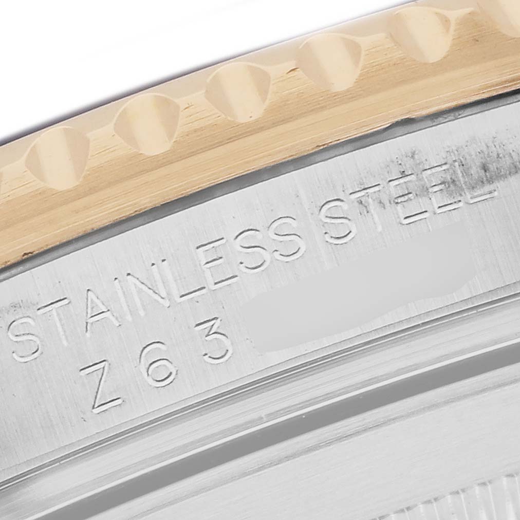 The image shows a close-up of the side of a Rolex Submariner 16613 Men's Steel and Gold (two tone) Blue Dial watch, focusing on the engraved bezel and case markings.