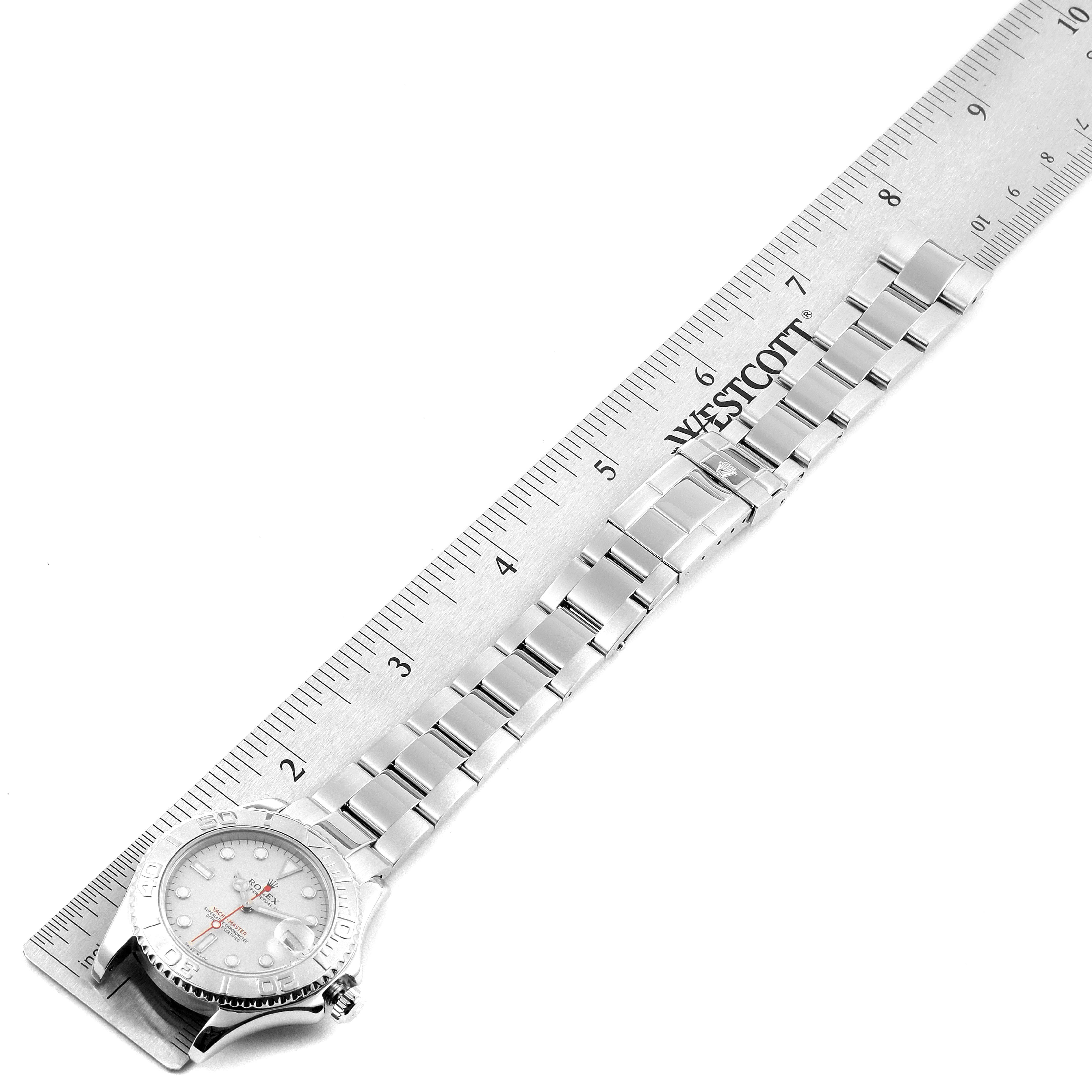 The image shows a top-down view of a Rolex Yacht-Master 168622 Men
s Stainless Steel Silver Dial 168622 Men
s Stainless Steel Silver Dial watch with its bracelet laid next to a ruler.