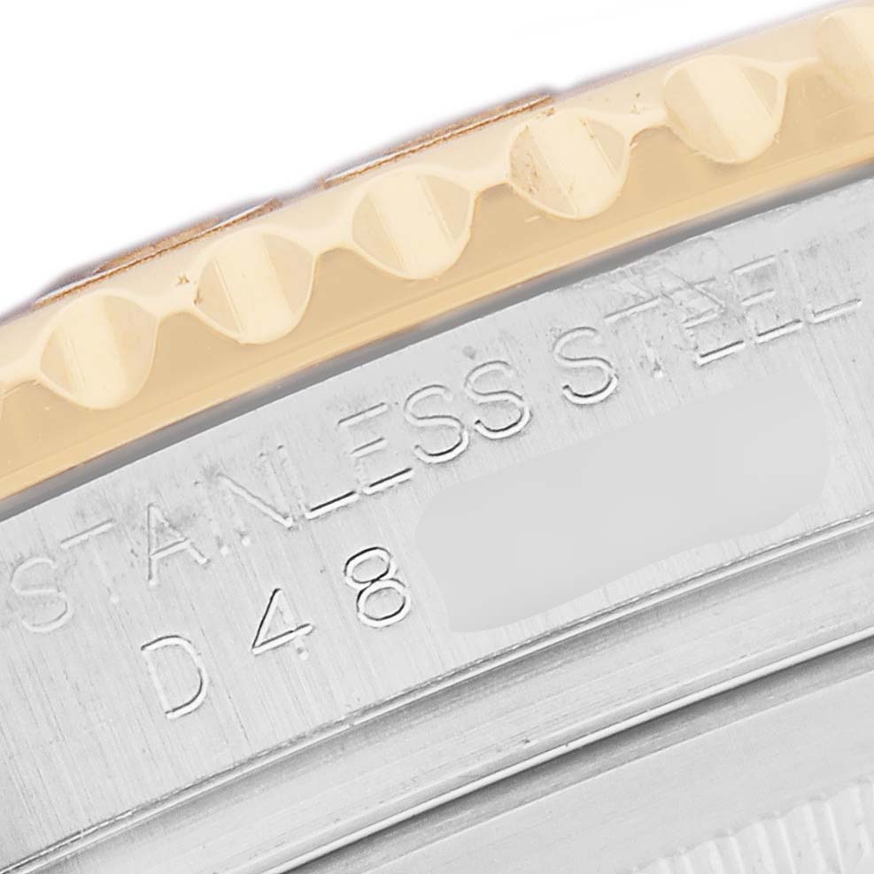 This image shows a close-up of the Rolex Yacht-Master 16623 Men
s Steel and Gold (two tone) Mother of Pearl Dial
s bezel and part of the stainless steel case, viewed from the side.