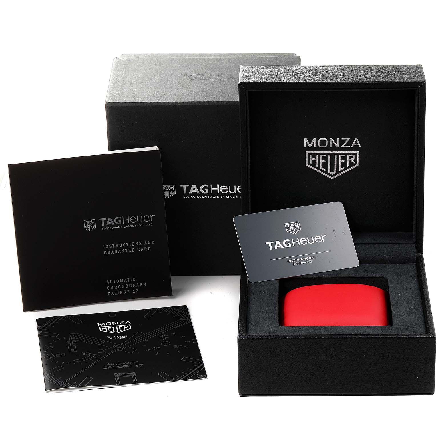 The image shows the packaging, instruction booklet, and warranty card for the Tag Heuer Monza watch.