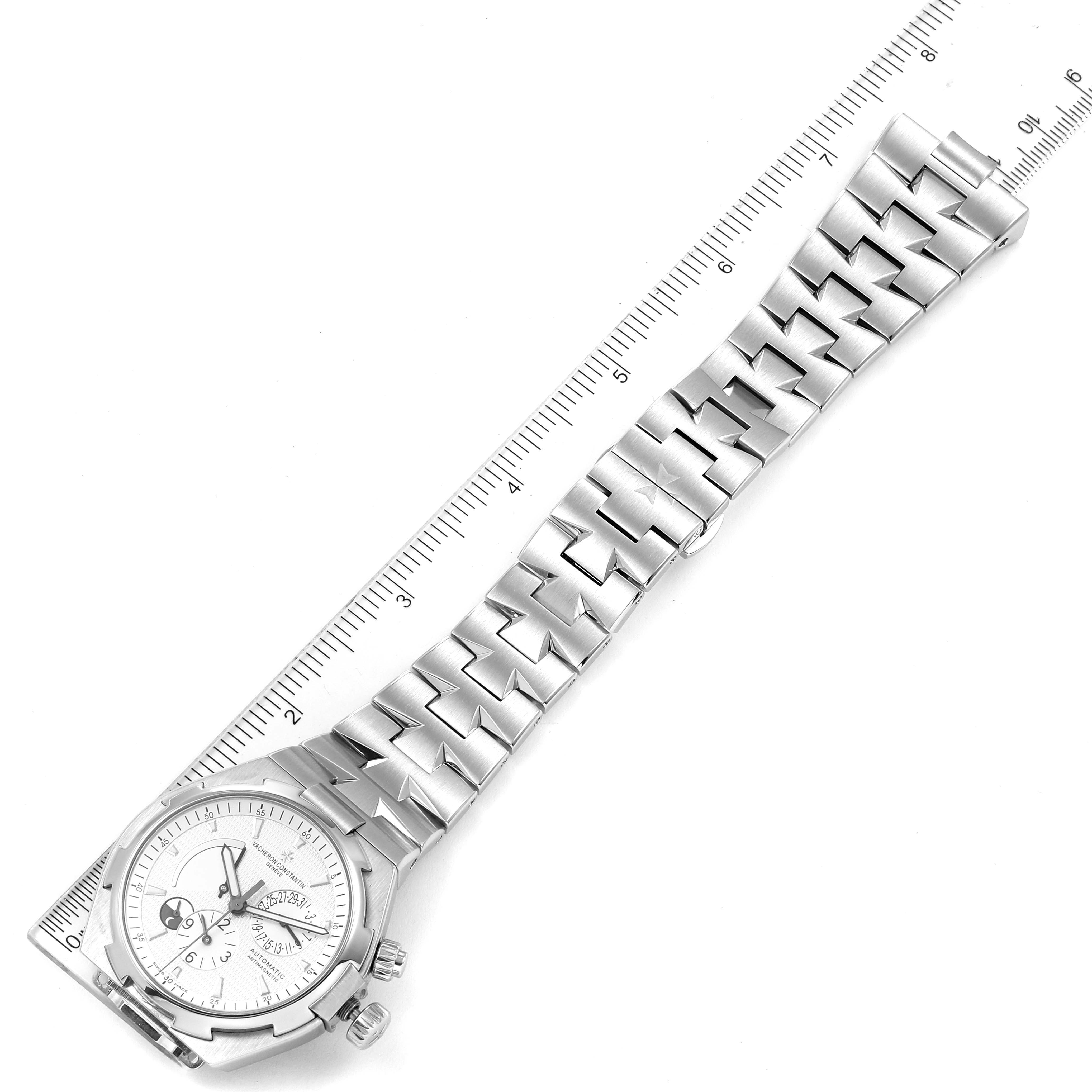 The Vacheron Constantin Overseas 47450/B01A-9226 Men
s Stainless Steel Silver Dial 47450/B01A-9226 Men
s Stainless Steel Silver Dial watch is shown from an overhead angle, featuring its dial, bracelet, and clasp, beside a ruler for scale.