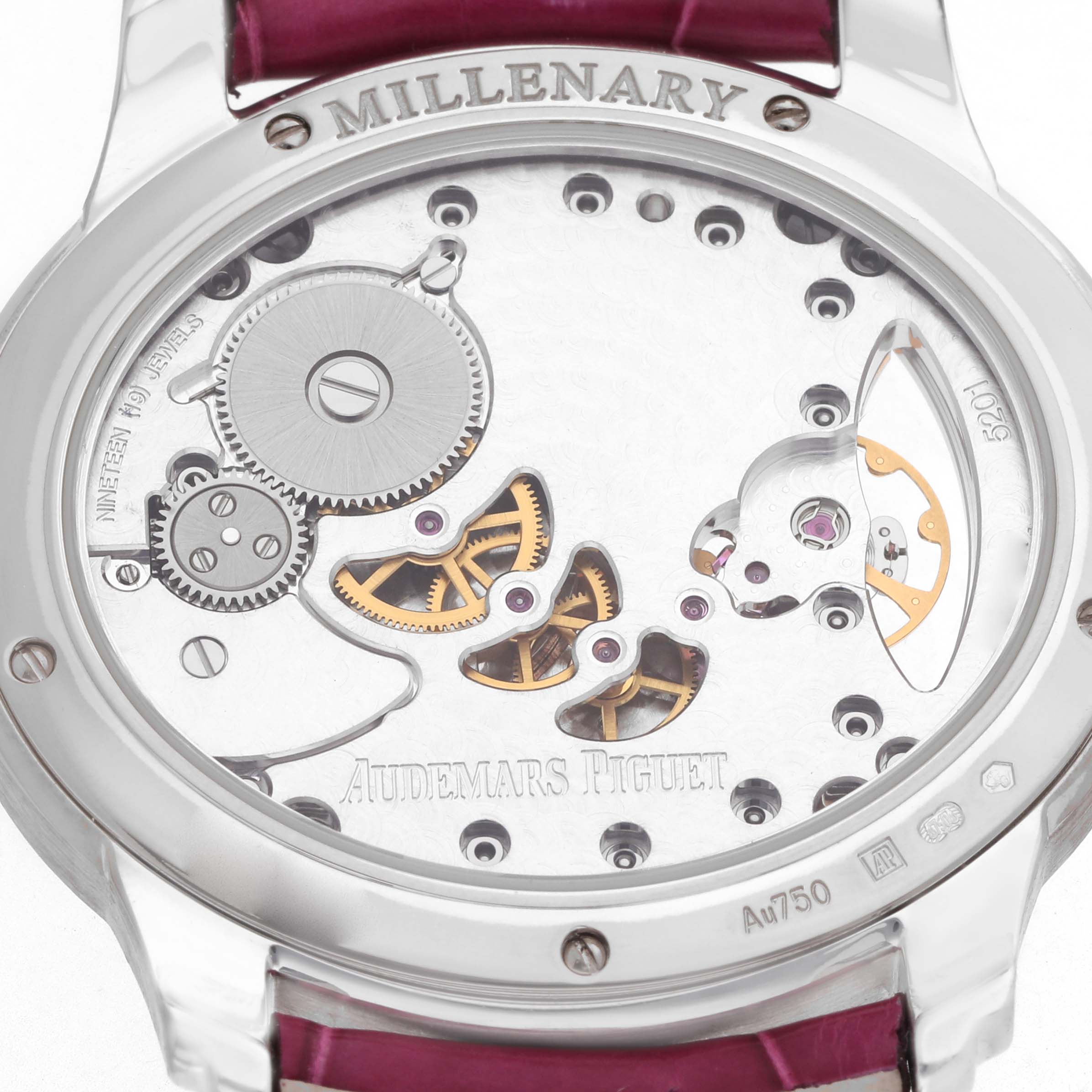 The image shows the back of an Audemars Piguet Millenary 77247BC Women's White Gold Mother of Pearl Dial watch, displaying its mechanical movement and engravings.