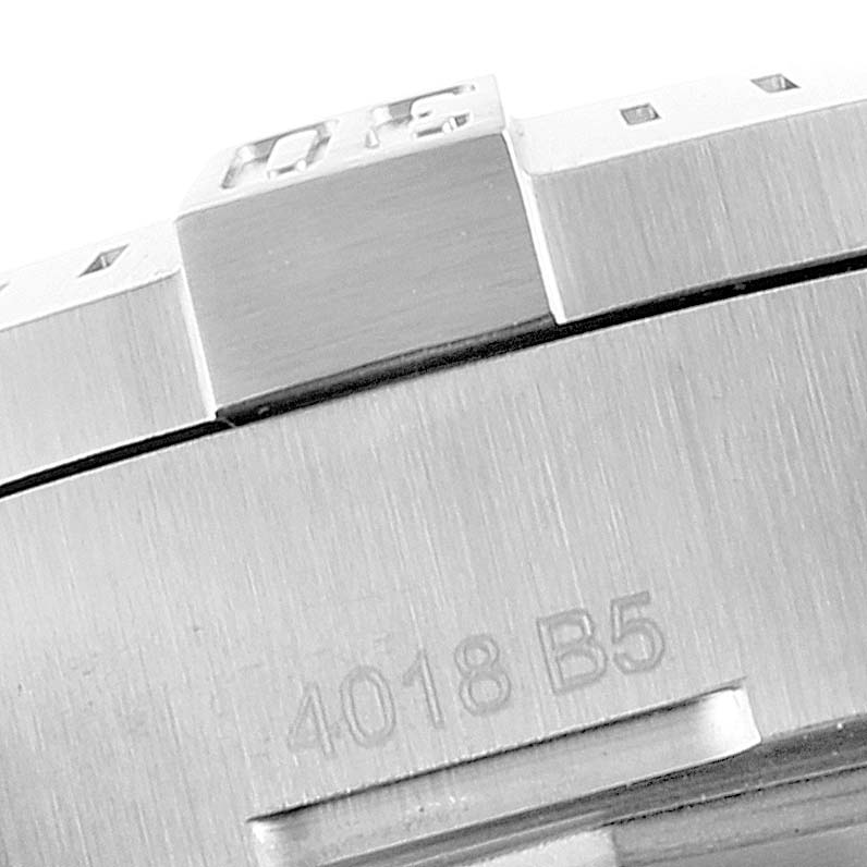 The image shows a close-up of the bezel and side case of a Breitling Colt A17313 Men's Stainless Steel White Dial A17313 Men's Stainless Steel White Dial watch with some engraved details.