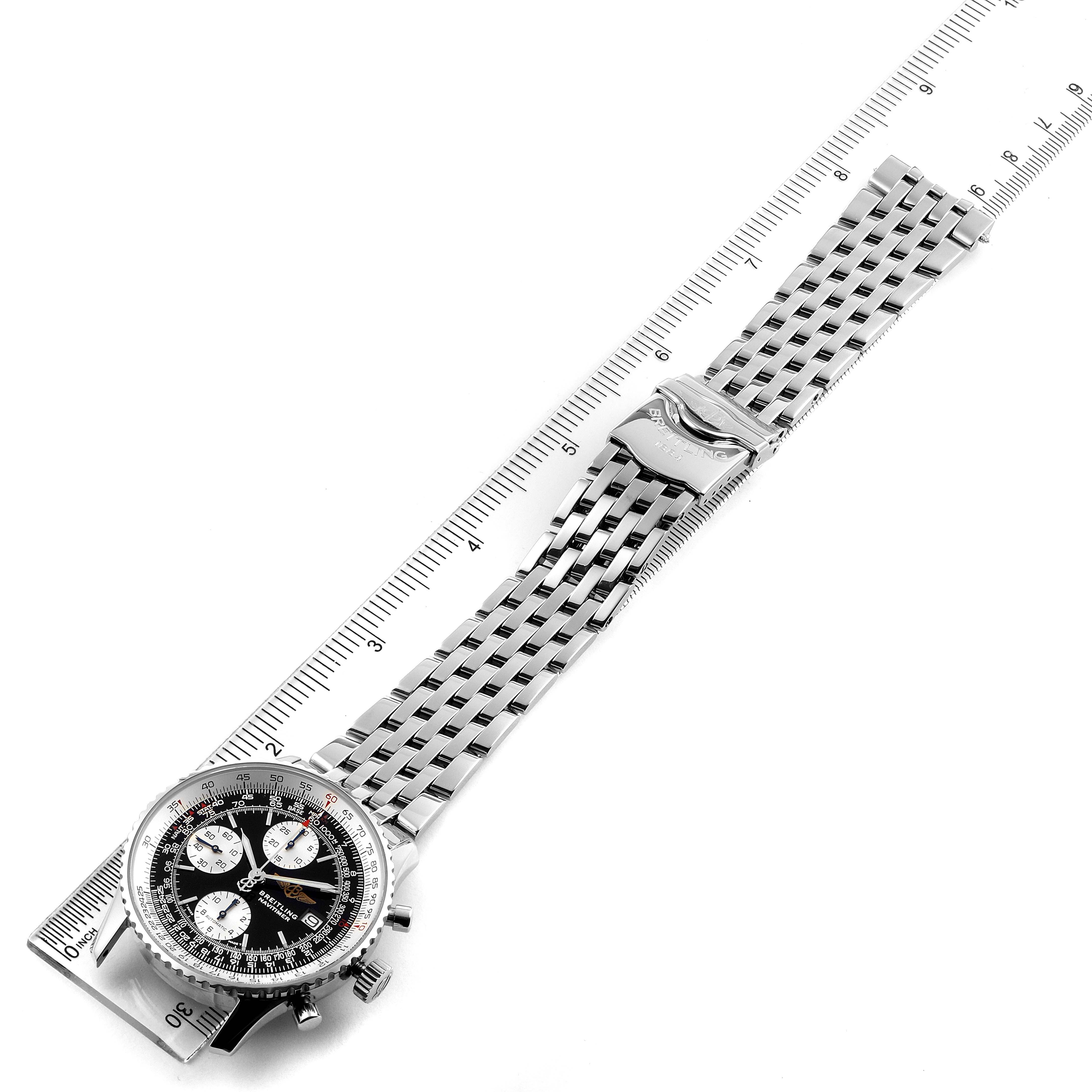 The image shows a top-down view of a Breitling Navitimer A13022 Men's Stainless Steel Black Dial A13022 Men's Stainless Steel Black Dial watch, highlighting its face and metal bracelet clasp placed on a ruler.