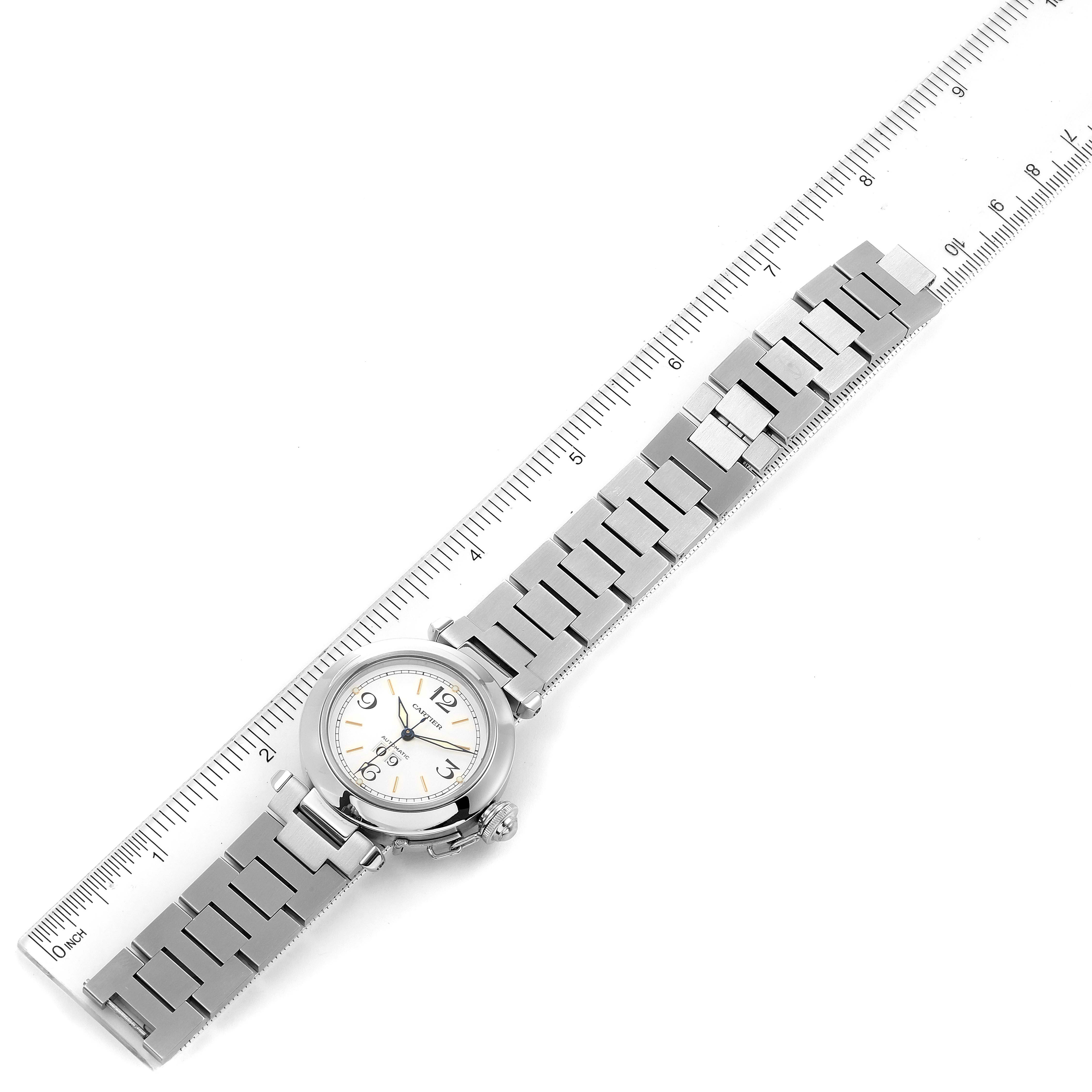 The image shows a top-down view of a Cartier Pasha W31044M7 Men's Stainless Steel White Dial W31044M7 Men's Stainless Steel White Dial watch with its entire metal bracelet laid out next to a ruler.
