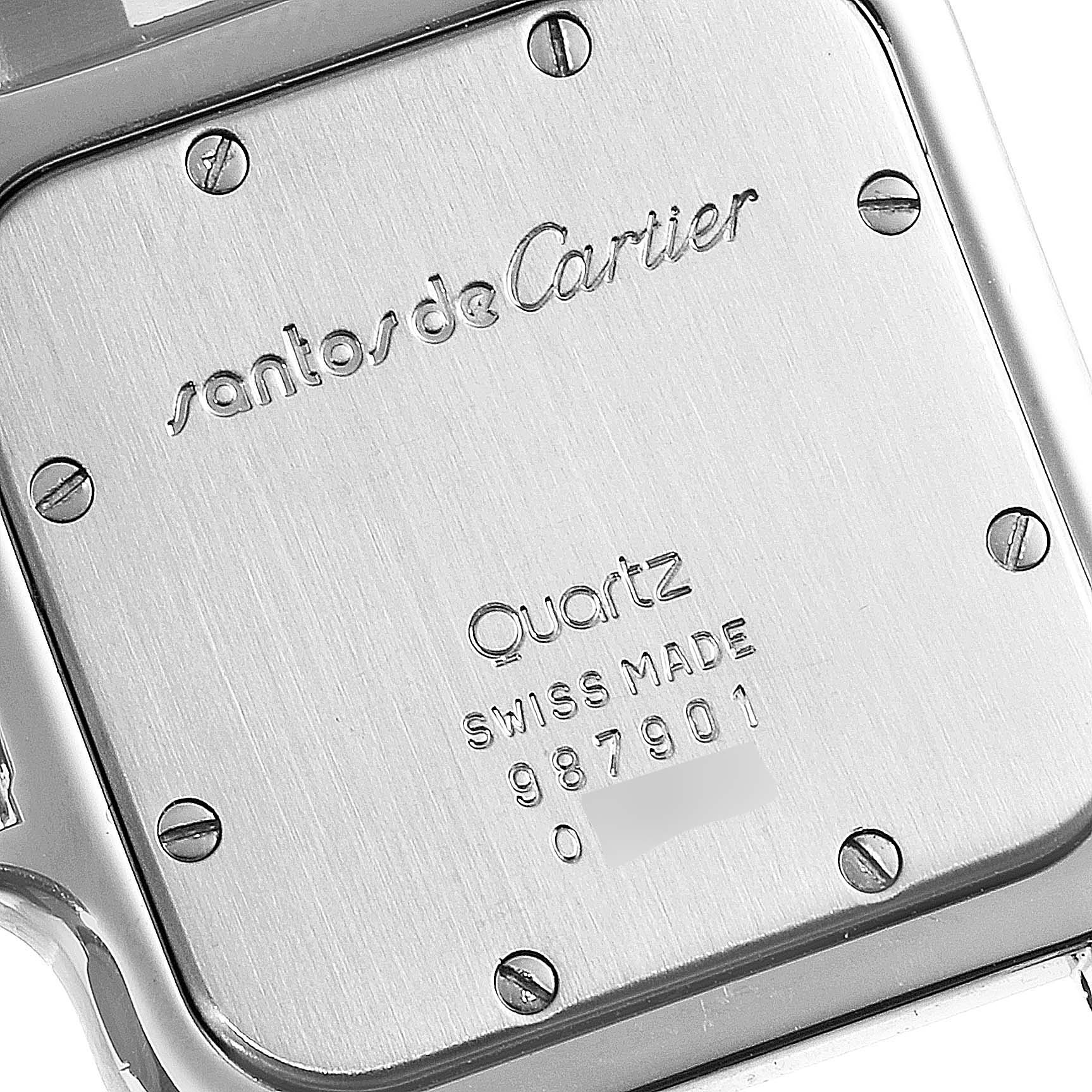 The image shows the back case of a Cartier Santos 987901 Women's Stainless Steel Silver Dial 987901 Women's Stainless Steel Silver Dial watch, highlighting the engraved brand name, model, and serial number.