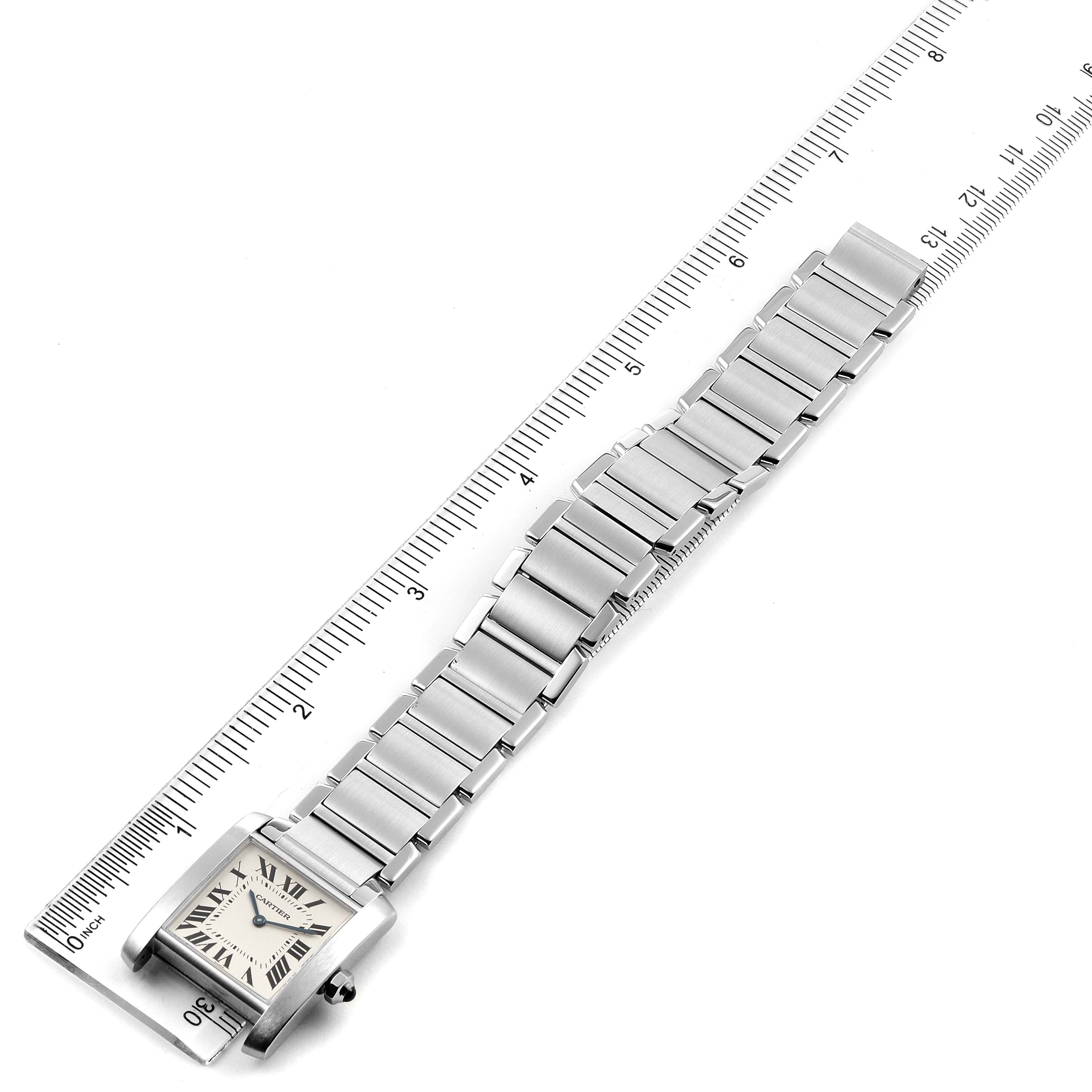 The image shows a Cartier Tank Francaise WSTA0005 Women
s Stainless Steel Silver Dial WSTA0005 Women
s Stainless Steel Silver Dial watch laid flat with a ruler next to it for size reference, displaying the face, bracelet, and clasp.