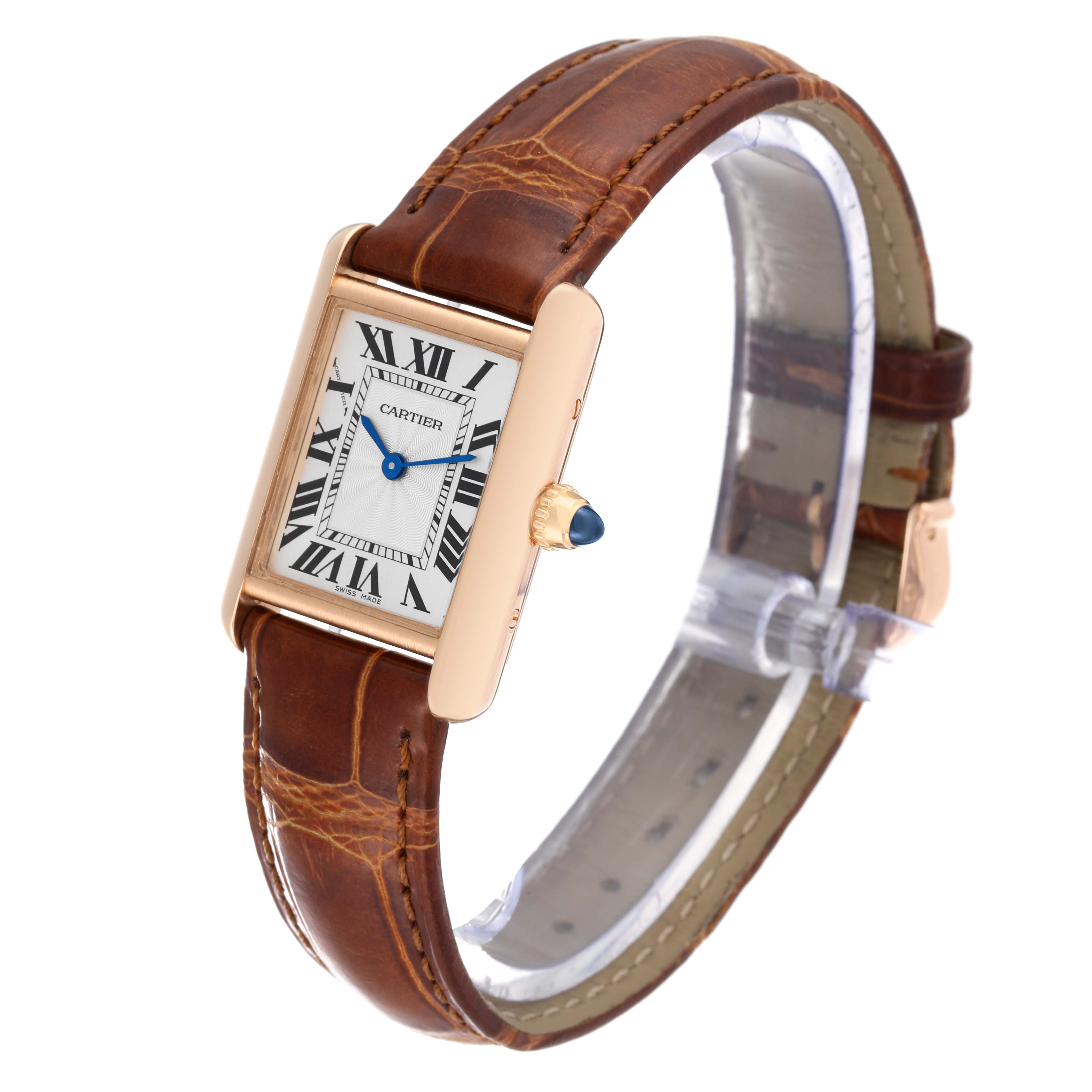 The Cartier Tank Louis WGTA0010 Women's Rose Gold Silver Dial WGTA0010 Women's Rose Gold Silver Dial watch is shown at a slight angle, displaying its rectangular face, leather strap, and signature blue cabochon crown.