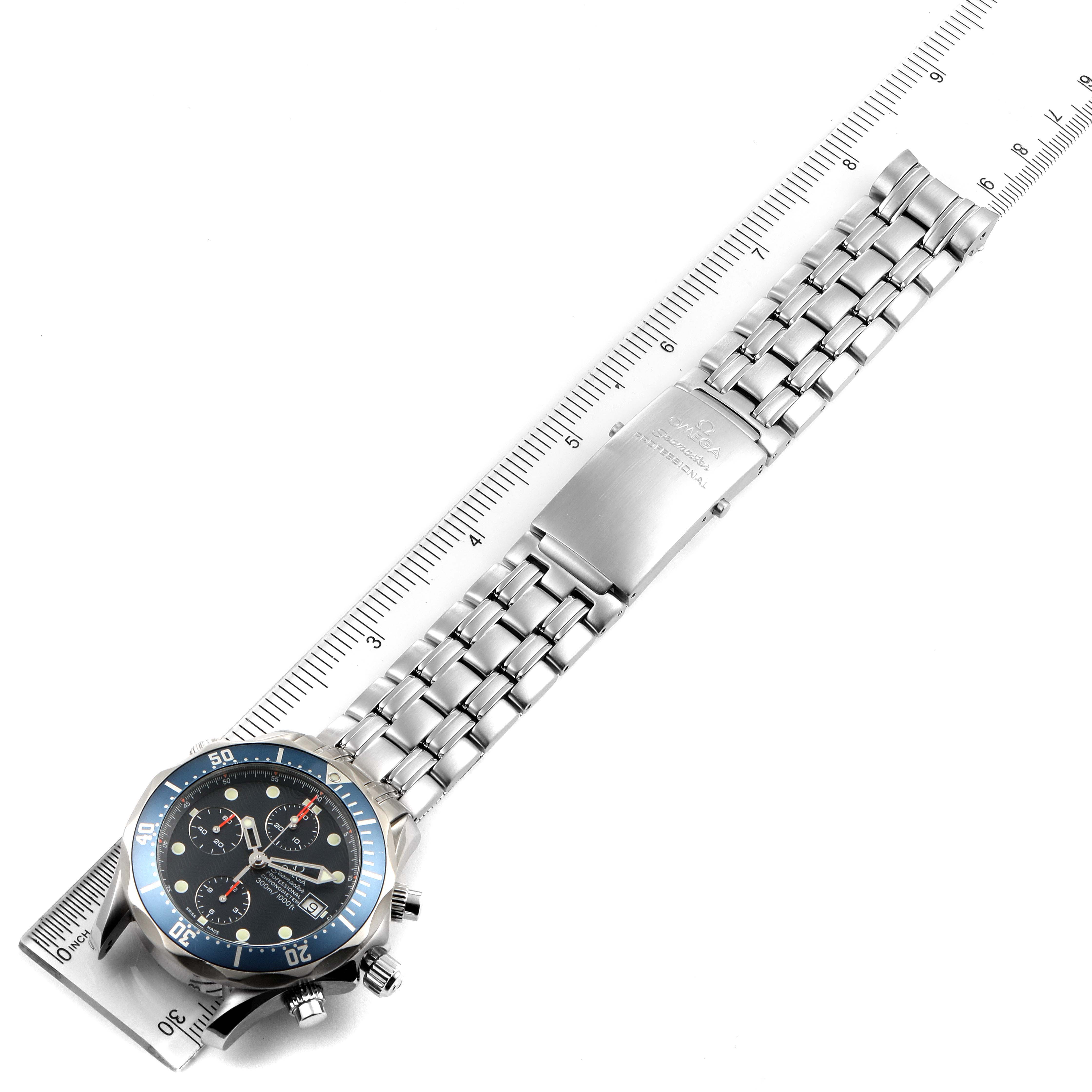 The image shows an overhead view of the Omega Seamaster 2599.80.00 Men
s Stainless Steel Blue Dial 2599.80.00 Men
s Stainless Steel Blue Dial watch, highlighting its face, bezel, and metal bracelet with a ruler for scale.