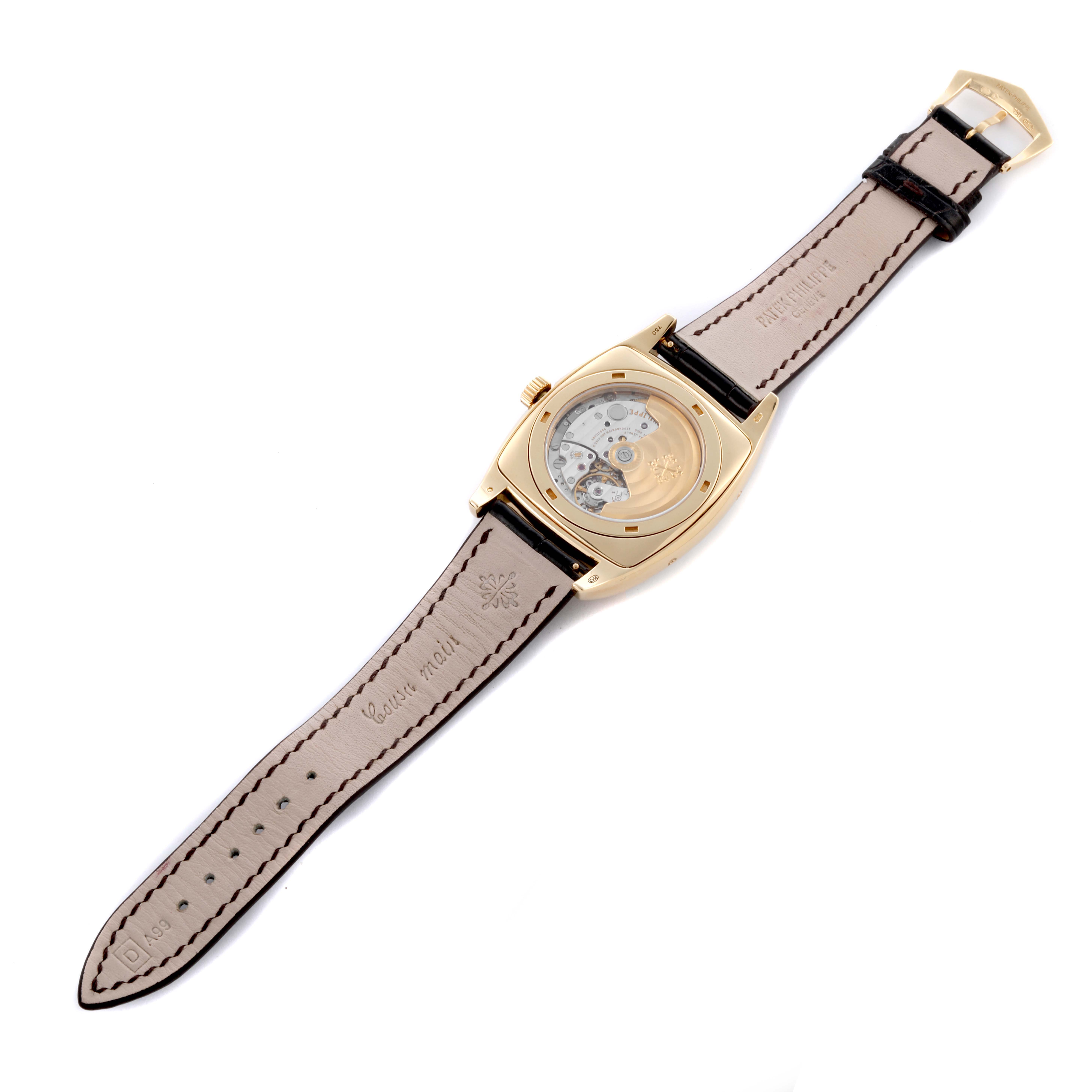 The image shows the back of a Patek Philippe Gondolo 5135J-001 Men's Yellow Gold Silver Dial 5135J-001 Men's Yellow Gold Silver Dial watch with an exposed movement and leather strap.